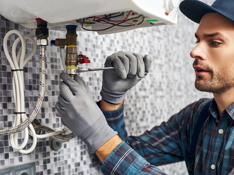 Residential water heater service being performed by HVAC technician in Nampa