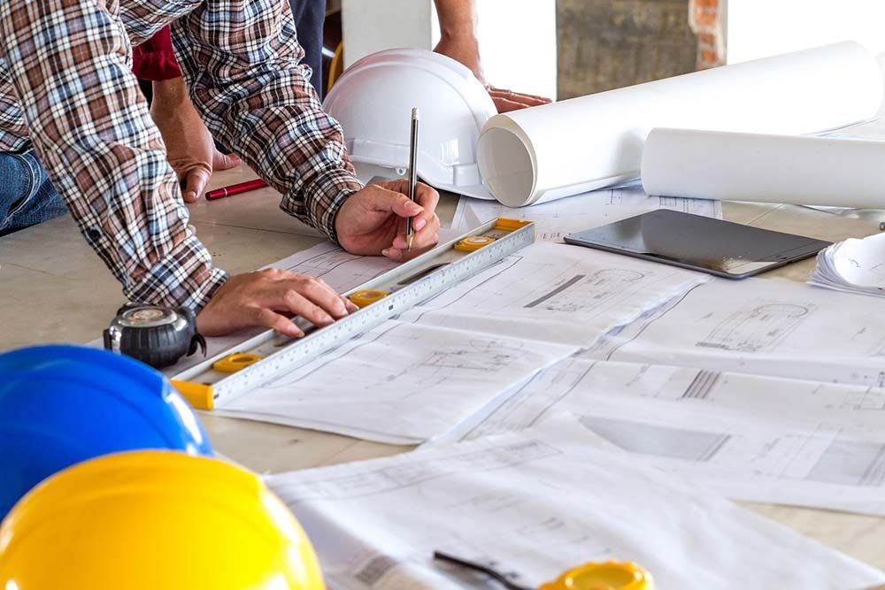 A man is measuring a piece of paper with a ruler.