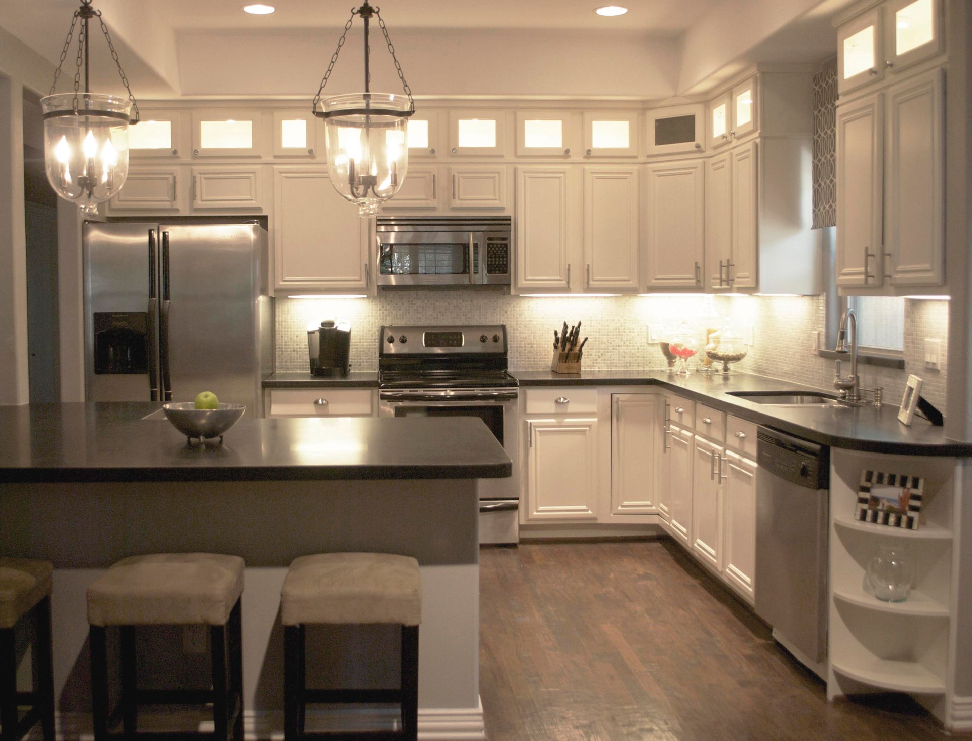 A kitchen with white cabinets and stainless steel appliances