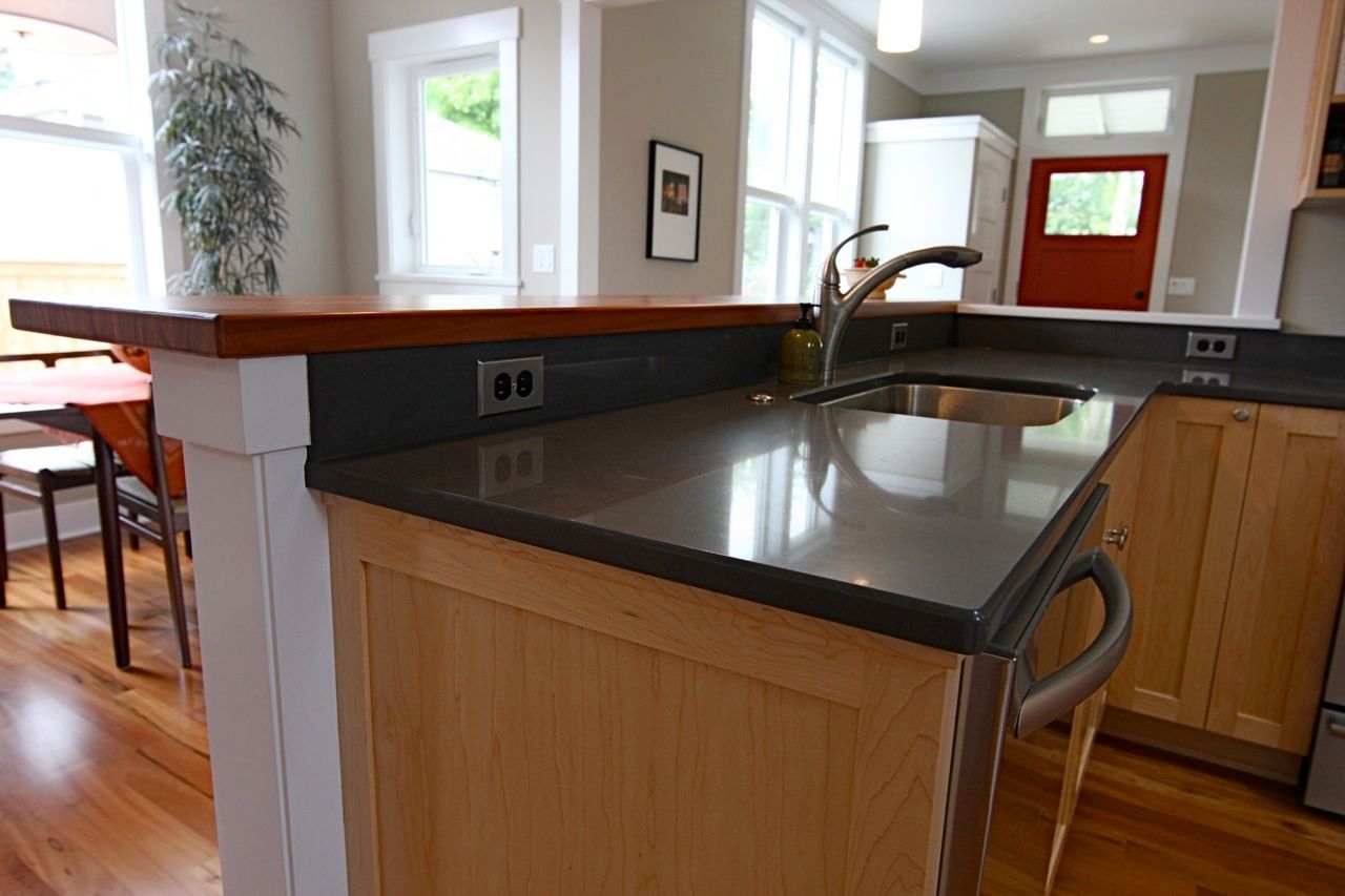 A kitchen with a sink and a wooden counter top