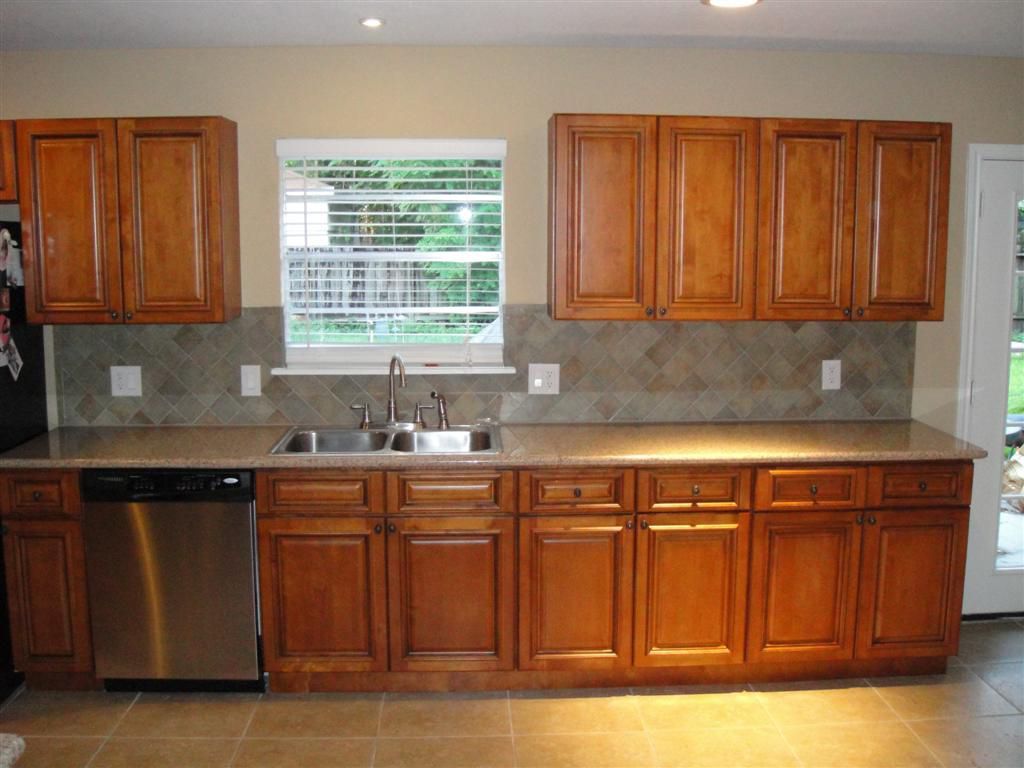 A kitchen with wooden cabinets and a stainless steel dishwasher