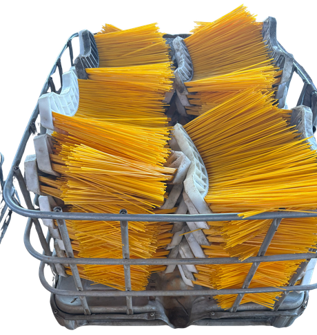 Basket of yellow-handled cleaning brushes in a gray metal wire basket