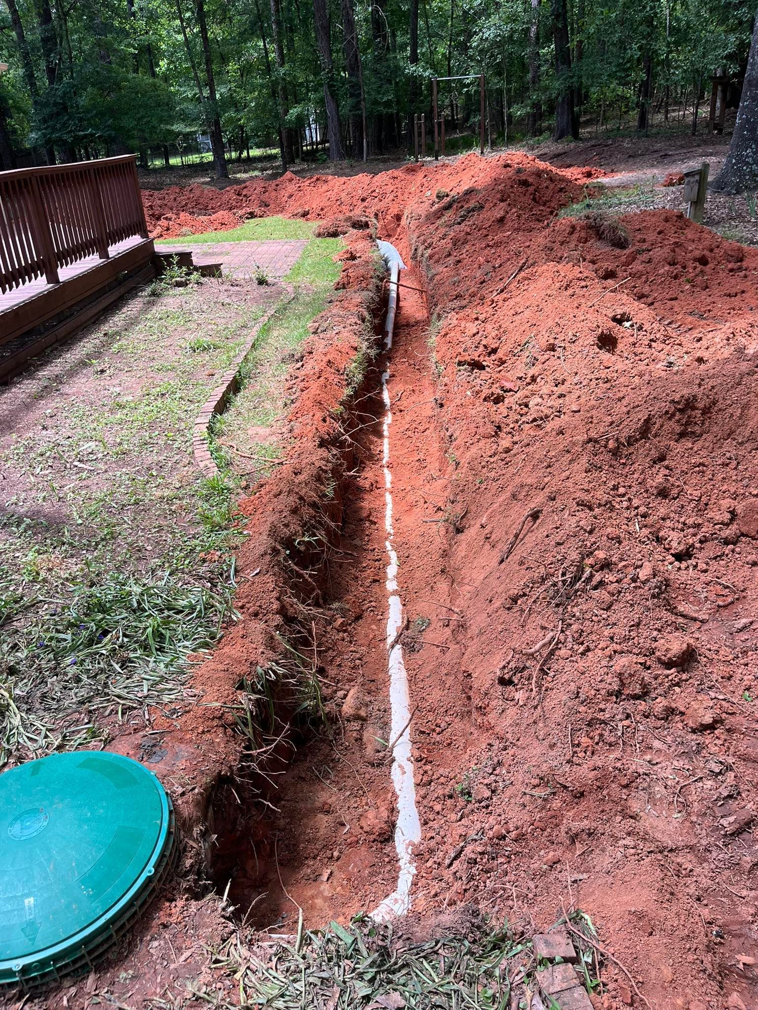 A large pile of dirt is in front of a house.