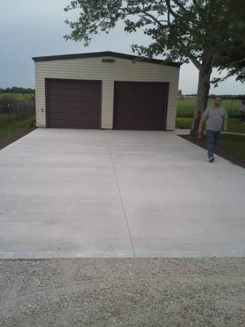 Concrete driveway with two-car garage, man walking.