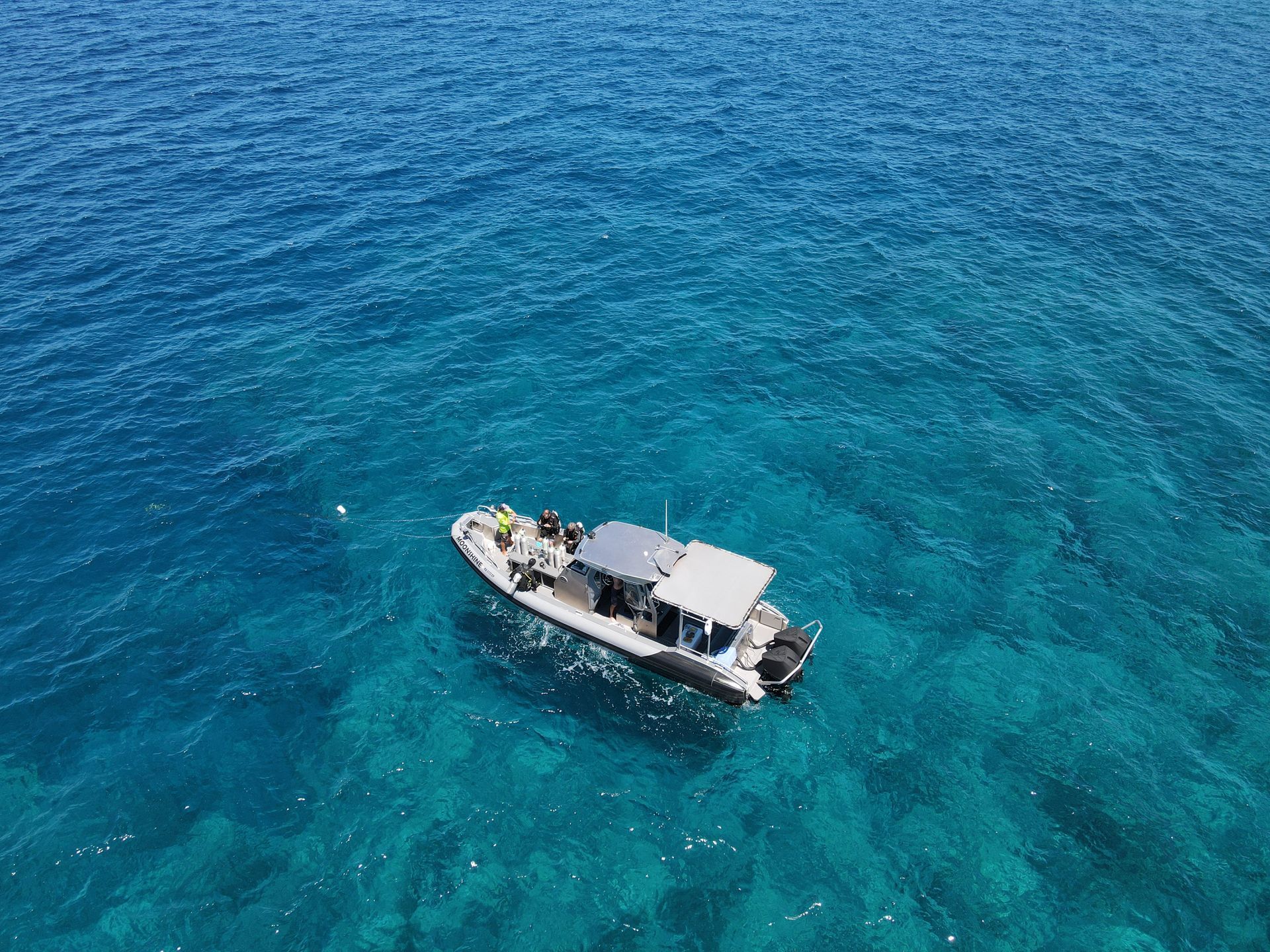 a man stands on a boat that says moonshine on the side