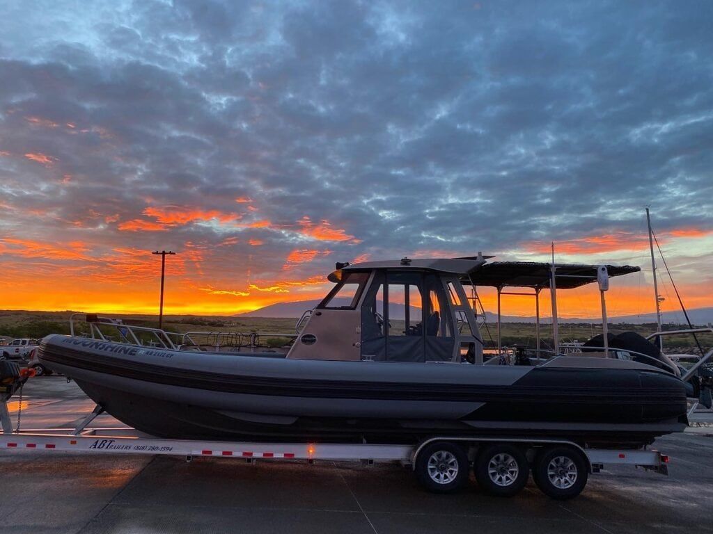 a boat on a trailer with a sunset in the background