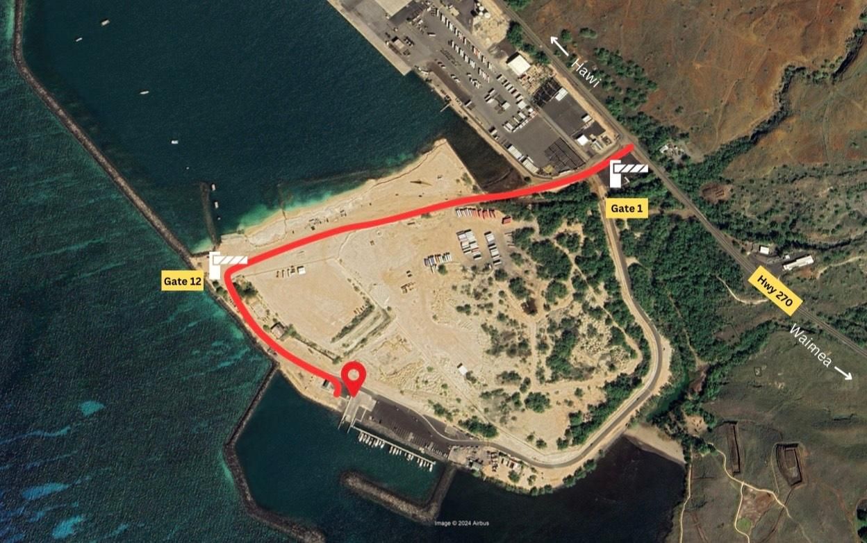 An aerial view of a Kawaihae harbor showing the red line and gates of how to drive to the harbor.