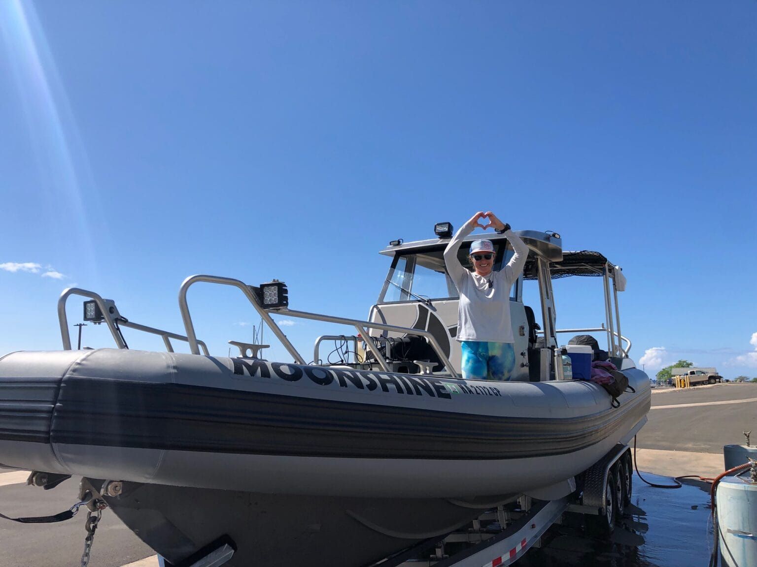 a man stands on a boat that says moonshine on the side