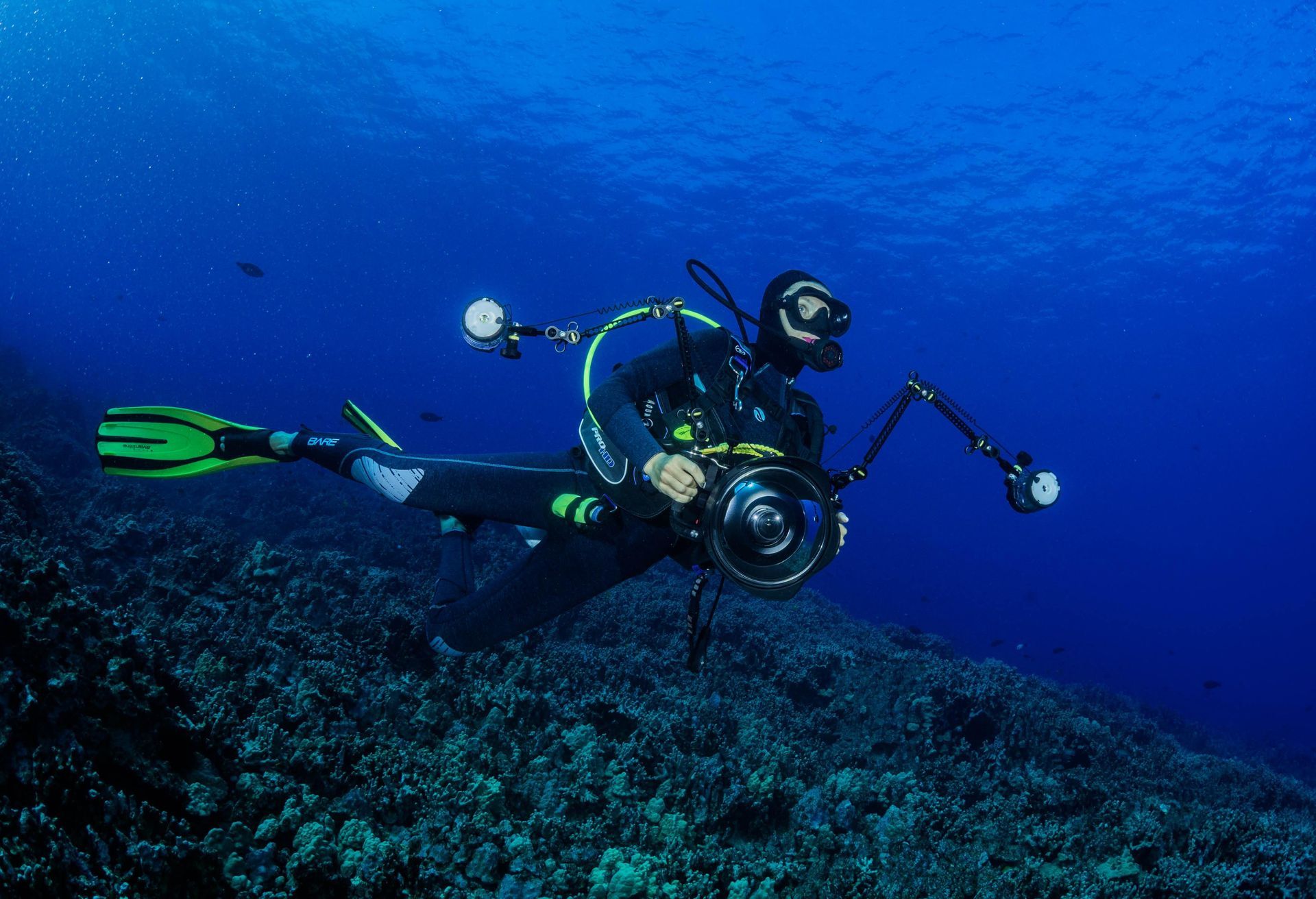 A scuba diver is taking a picture of a coral reef in the ocean.