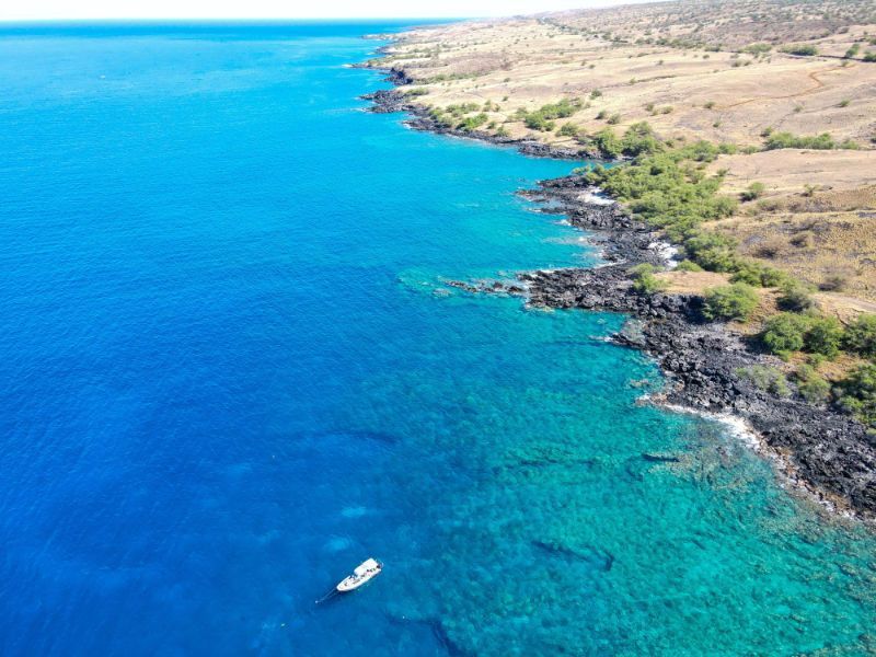 an aerial view of Kohala coast with a boat in it