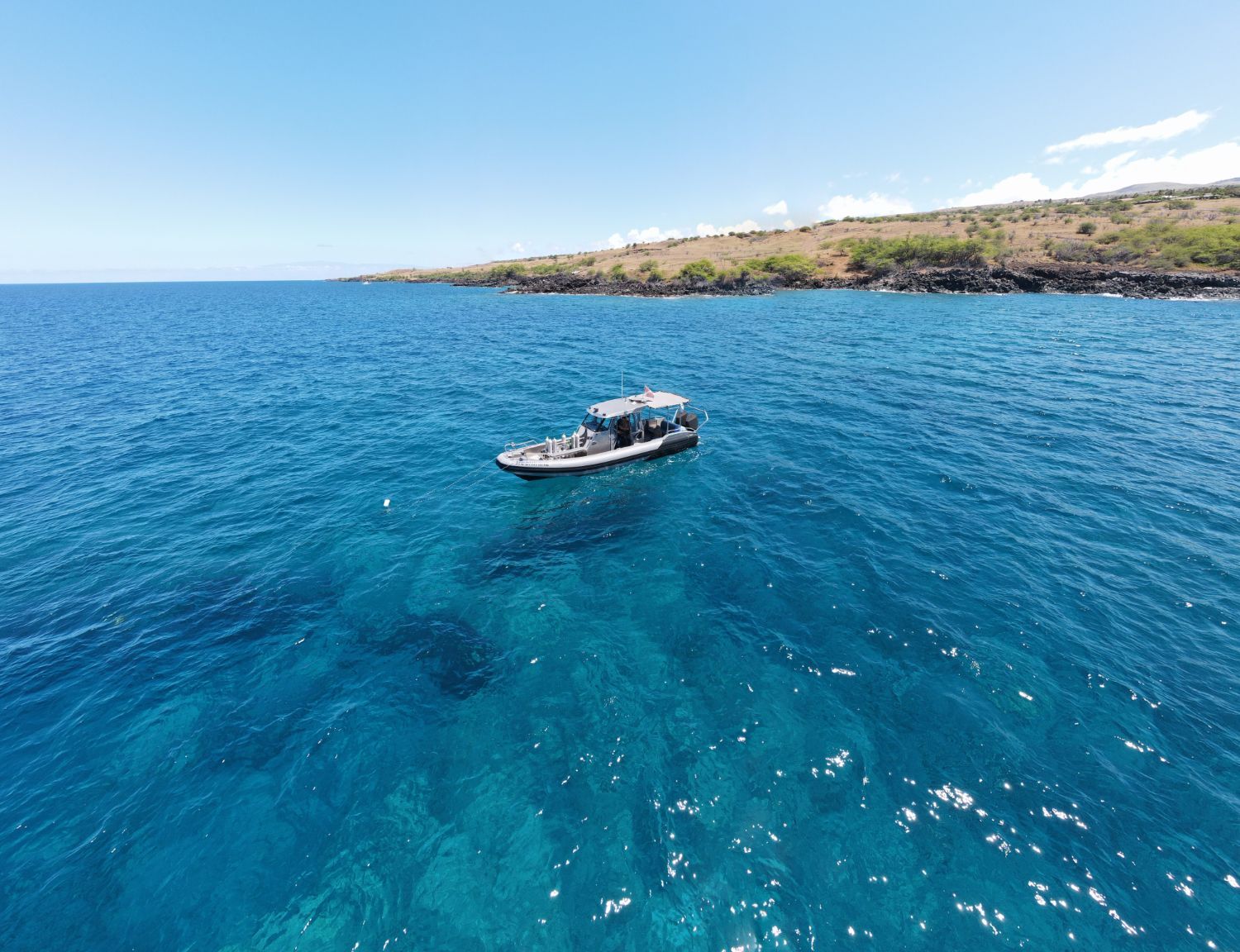 An aerial view of a boat in the middle of the ocean.