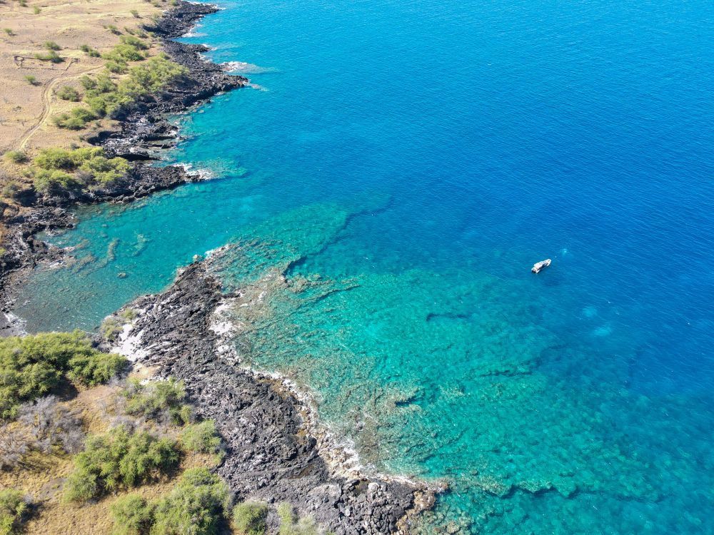 An aerial view of a body of water with a boat in it.