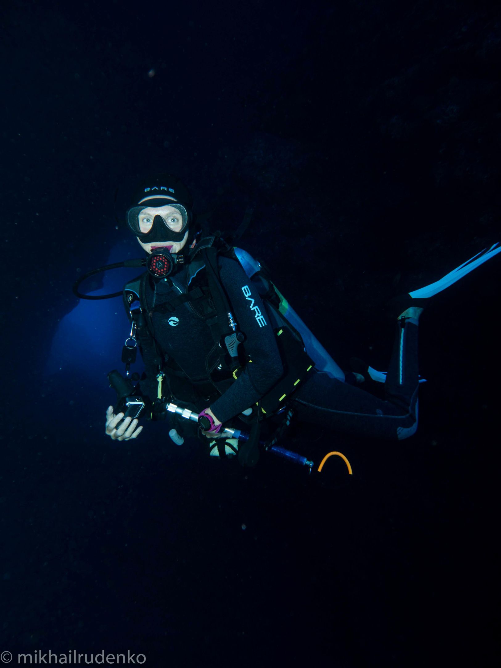 a scuba diver is swimming in a lava tube