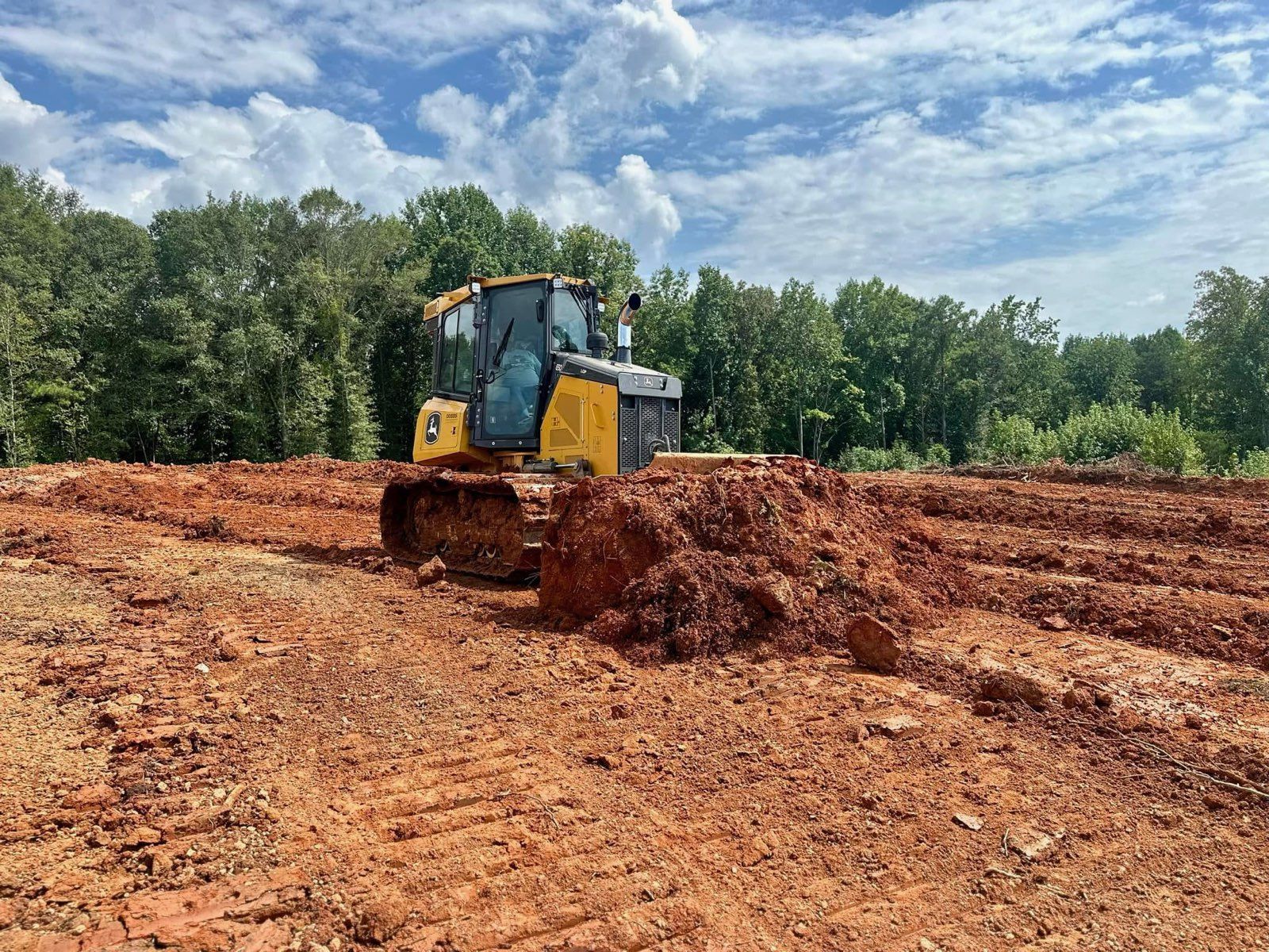 A bulldozer is moving dirt in front of a house.