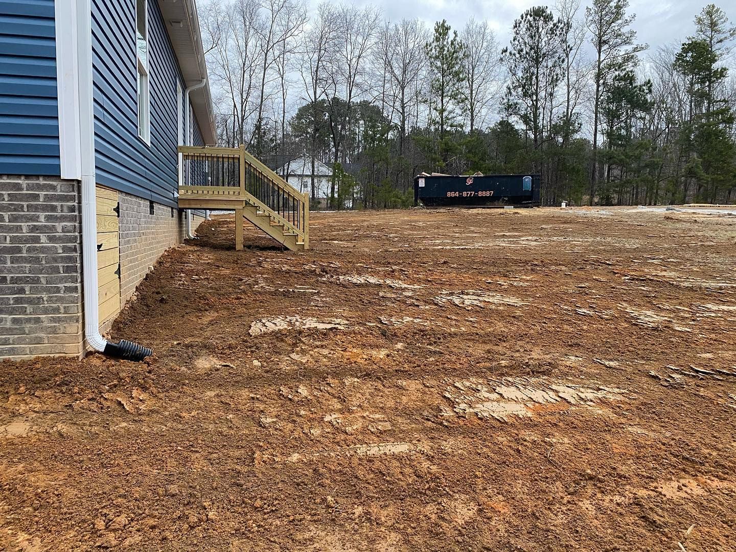 A house is sitting on top of a dirt hill.