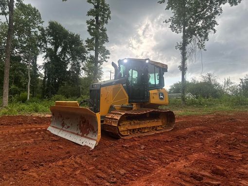 A bulldozer is sitting in the middle of a forest.