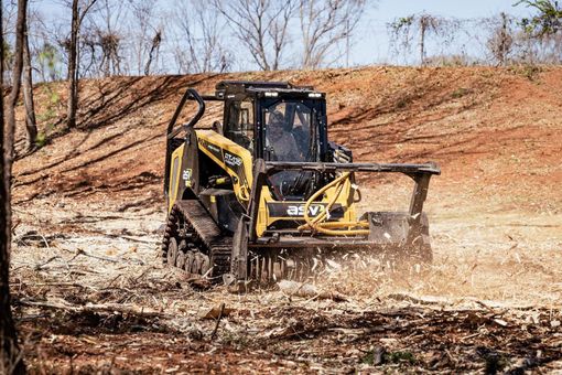 A bulldozer is cutting down trees in a forest.