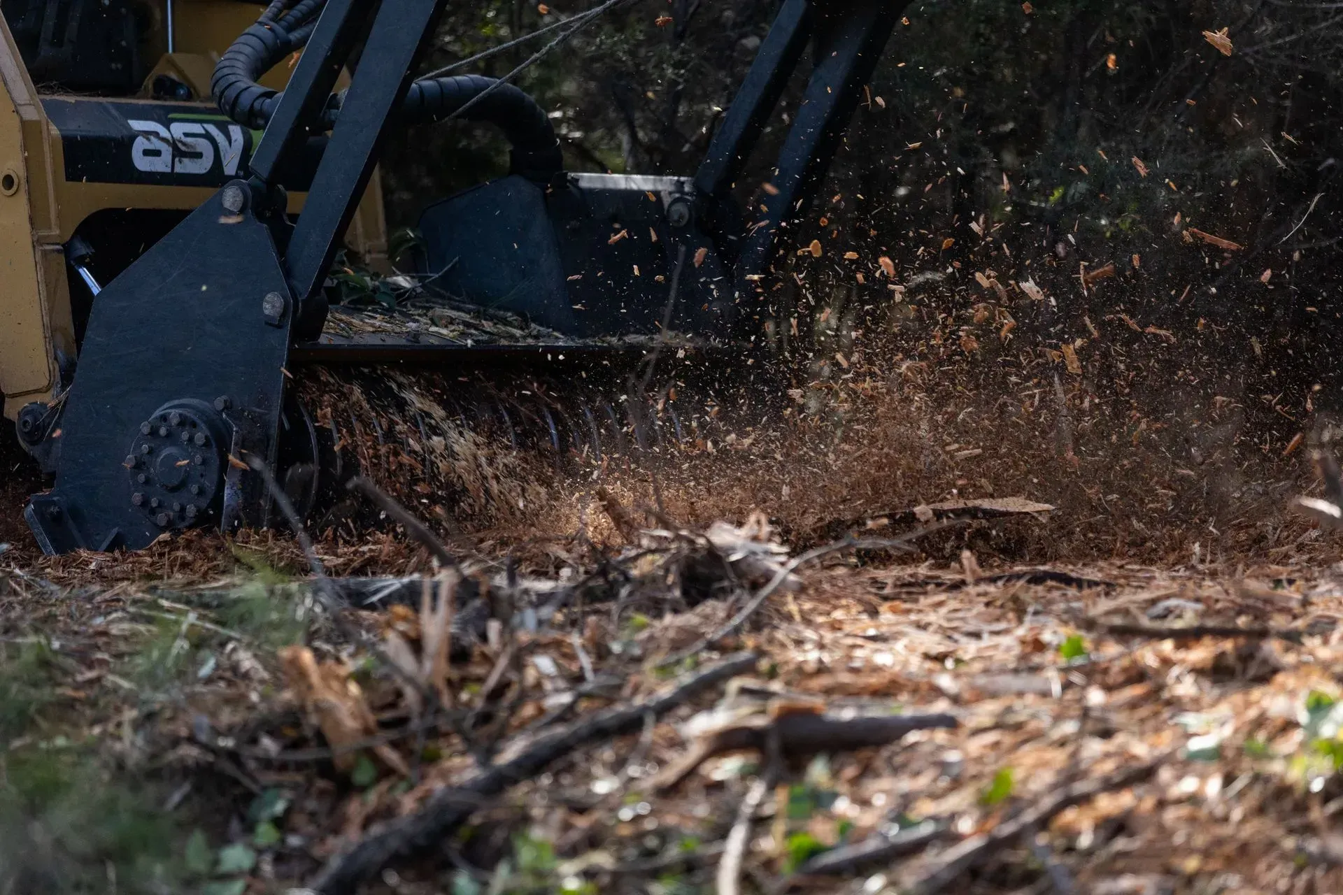 A machine is cutting a tree stump in the ground.