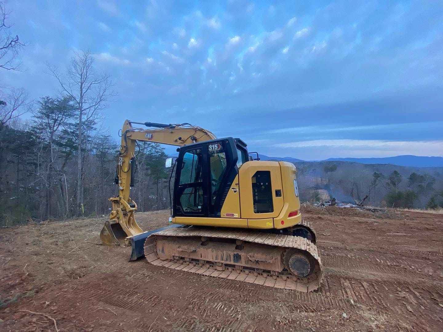 A bulldozer is digging a hole in a dirt field.