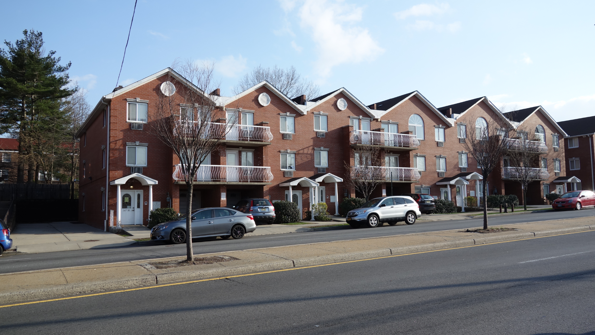 Yellow, weathered house with rusty roof, porch, and screen door; grassy yard.