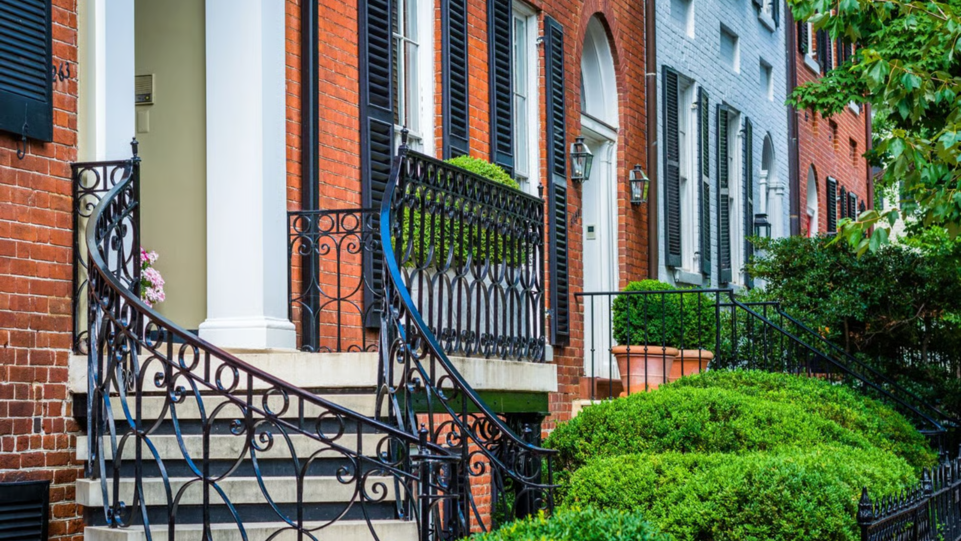 Two-story house with gray siding, brown accents, and a white garage door, blue sky in the background.