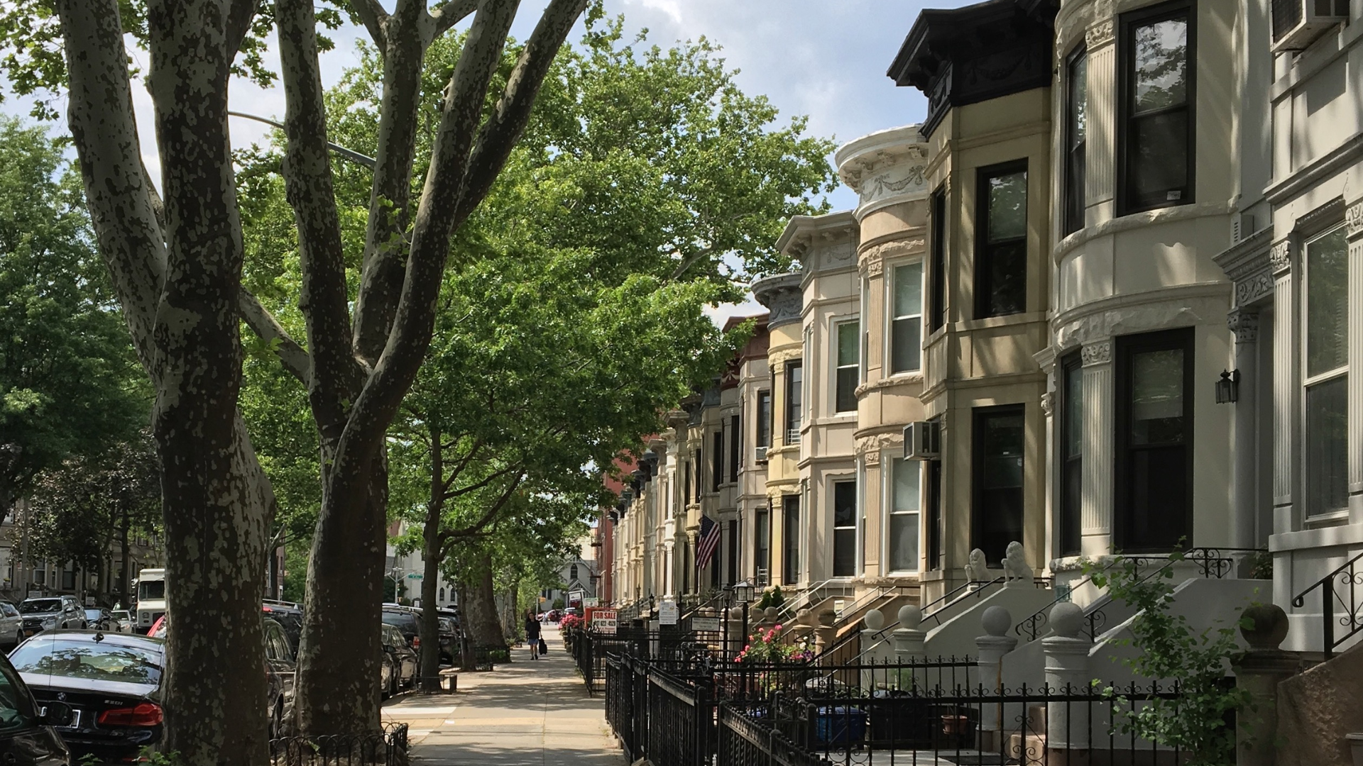 Modern house exterior with stone facade, steps, dark door, and sidelights.