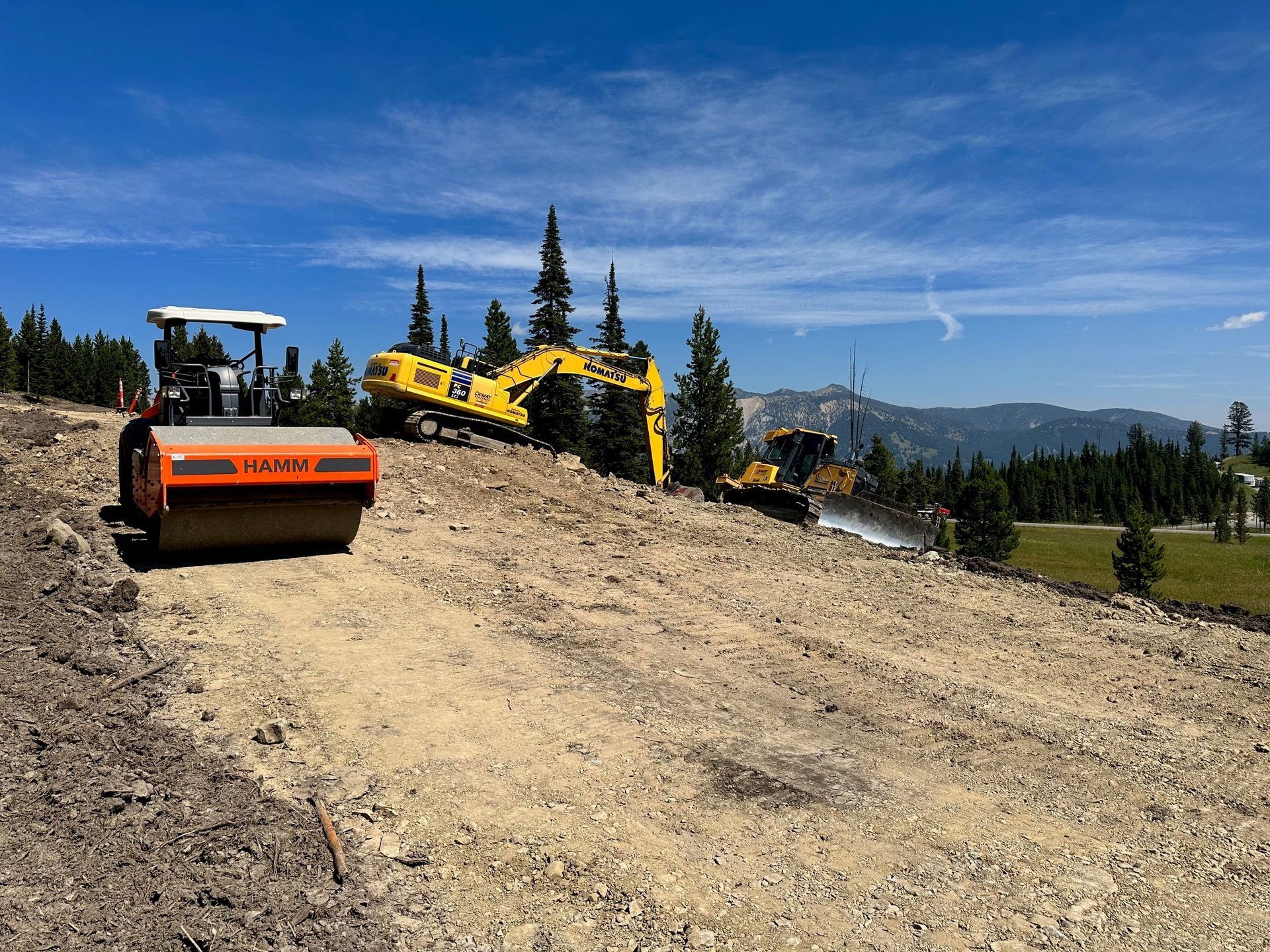A construction site with a roller and a bulldozer on it.