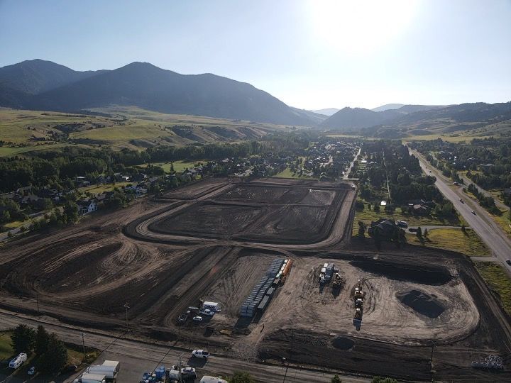 An aerial view of a construction site with mountains in the background.