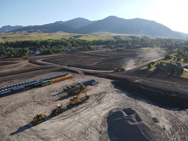 An aerial view of a construction site with mountains in the background.