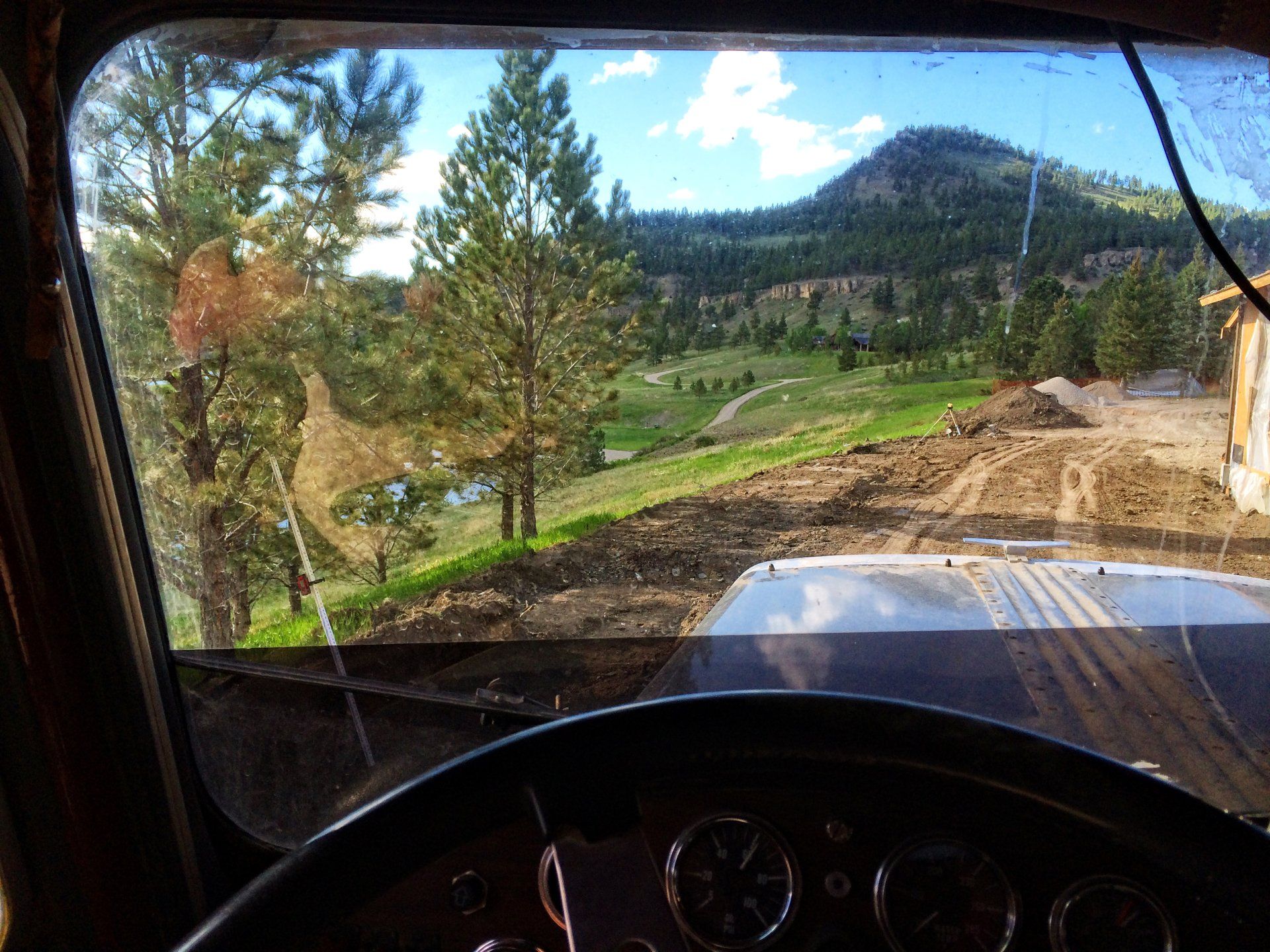 A truck is driving down a dirt road with trees in the background.