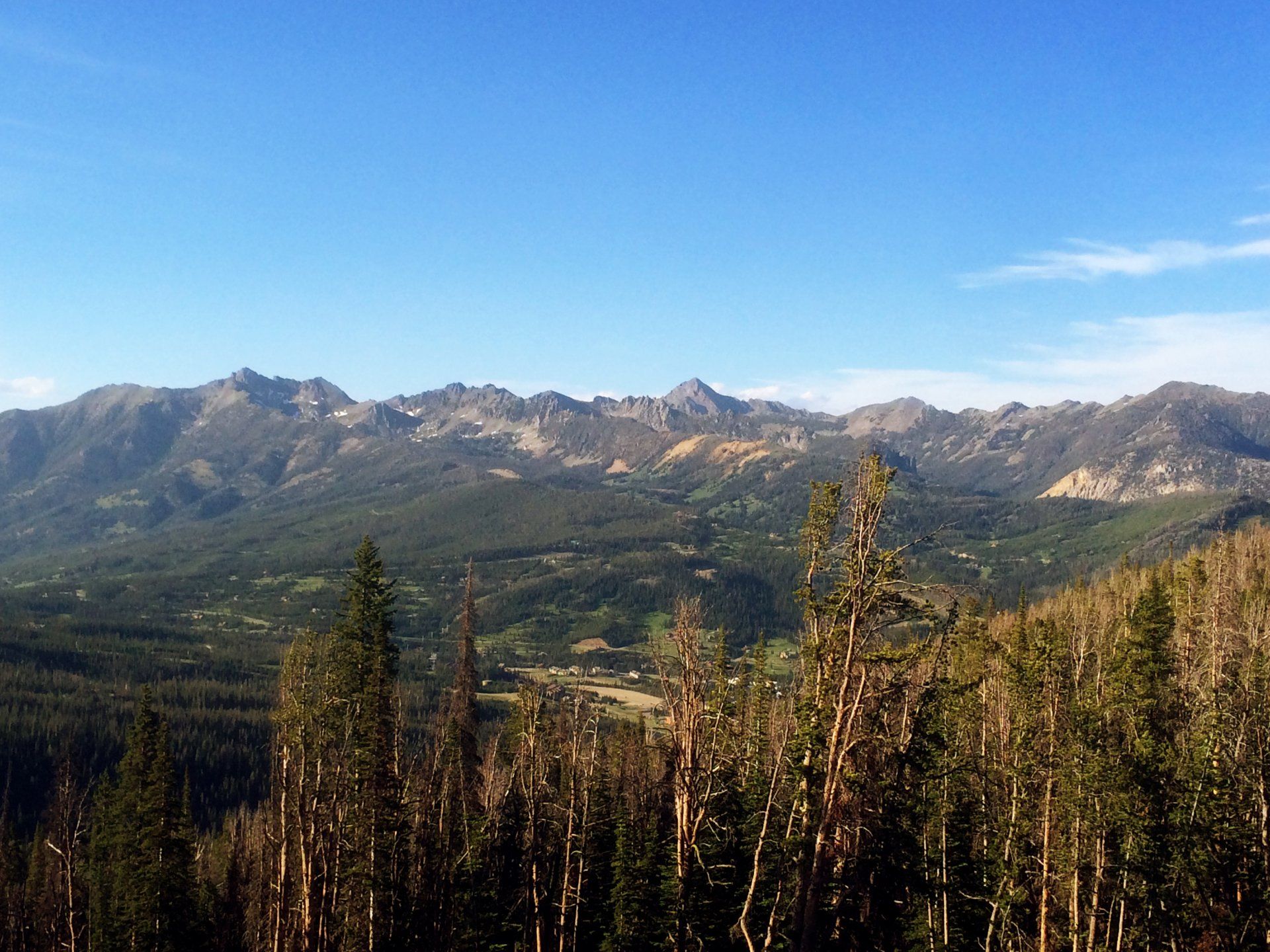 A view of a mountain range with trees in the foreground