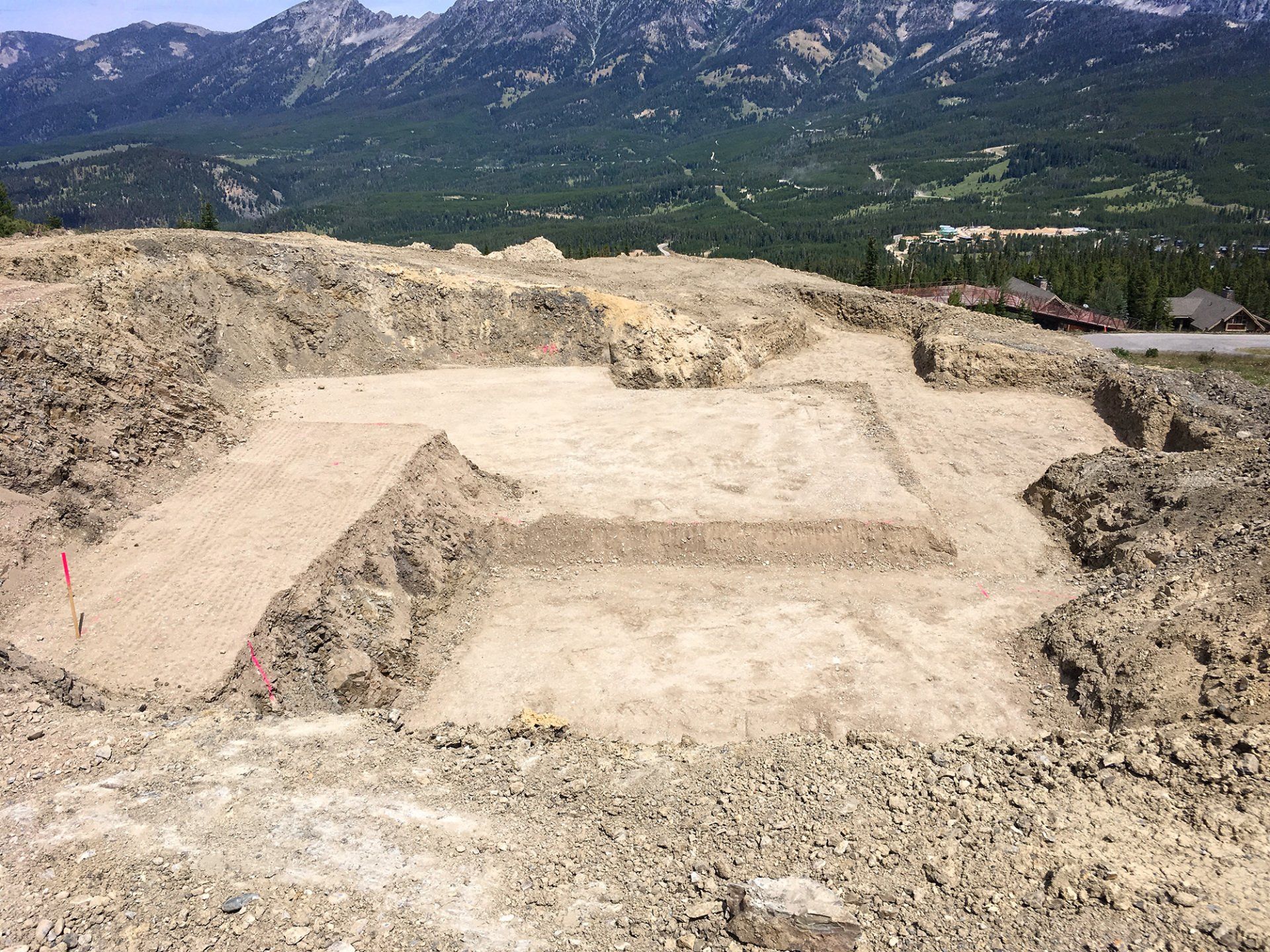 A large dirt field with mountains in the background.