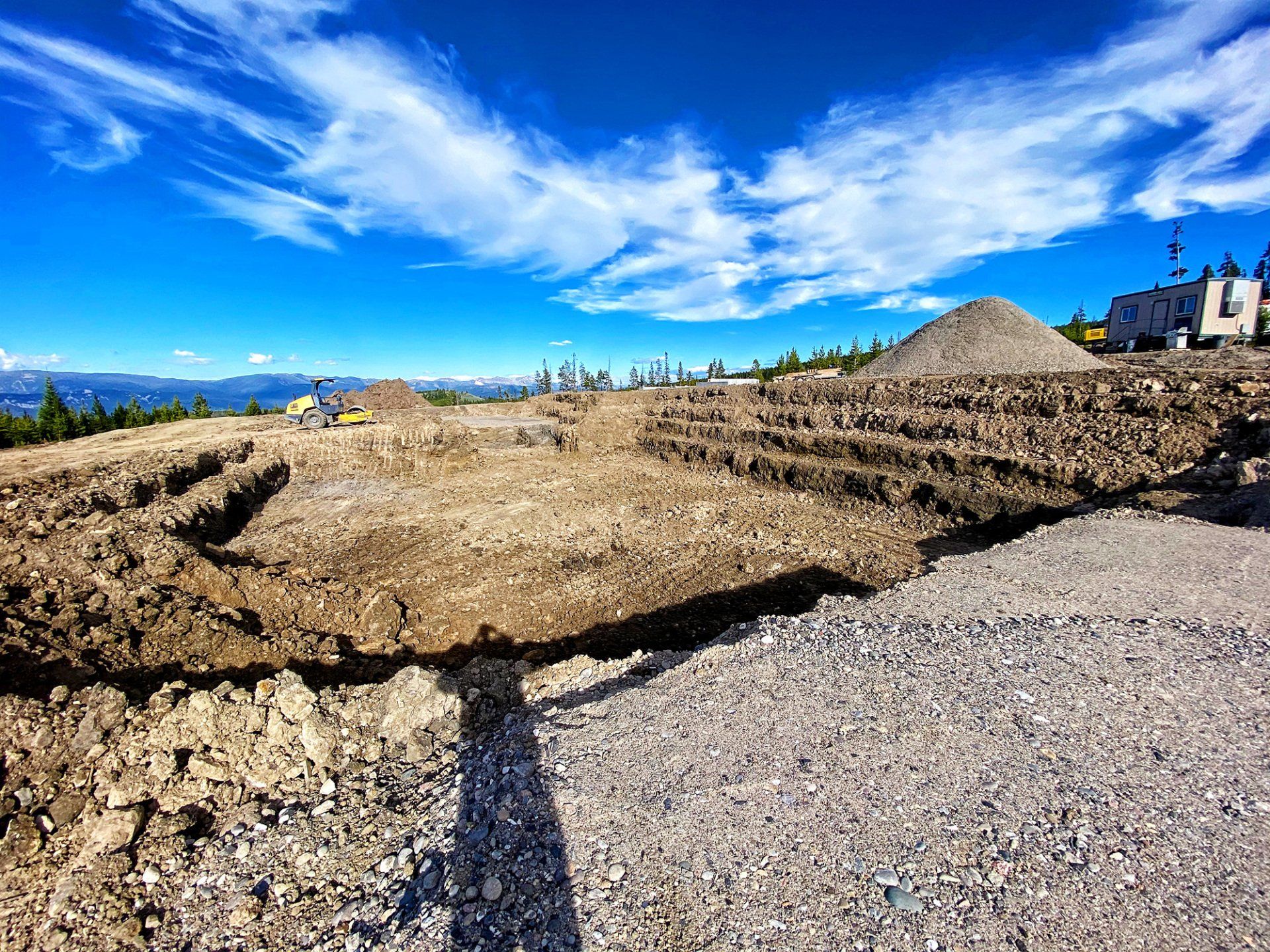 A large pile of dirt and gravel is sitting on top of a dirt field.