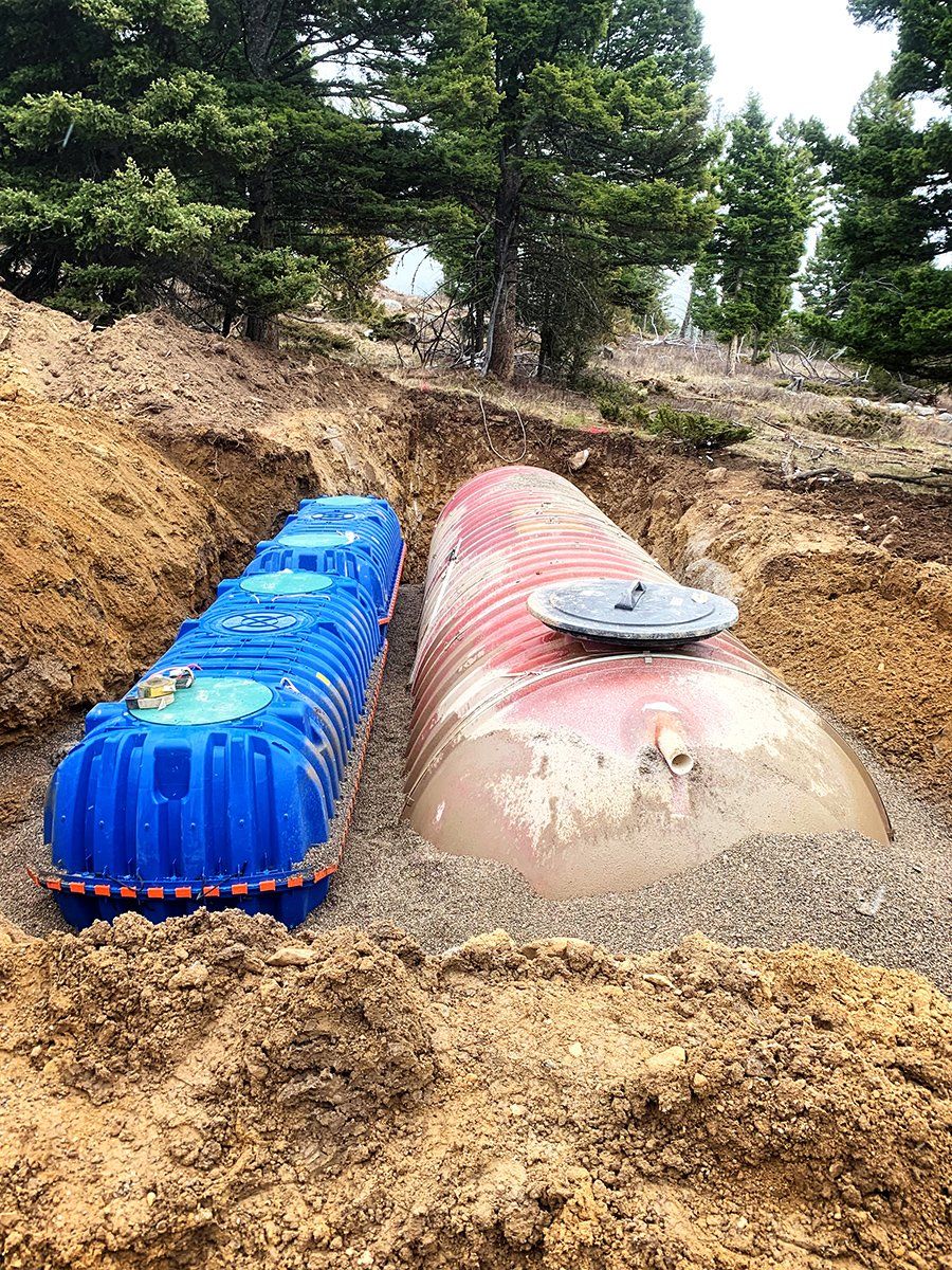 A blue tank and a red tank are sitting in the dirt.