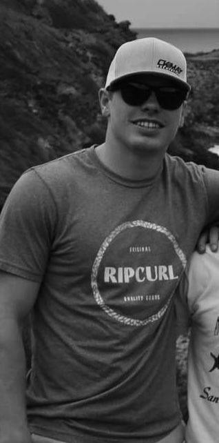 A man in a suit and tie is wearing an orange hard hat.