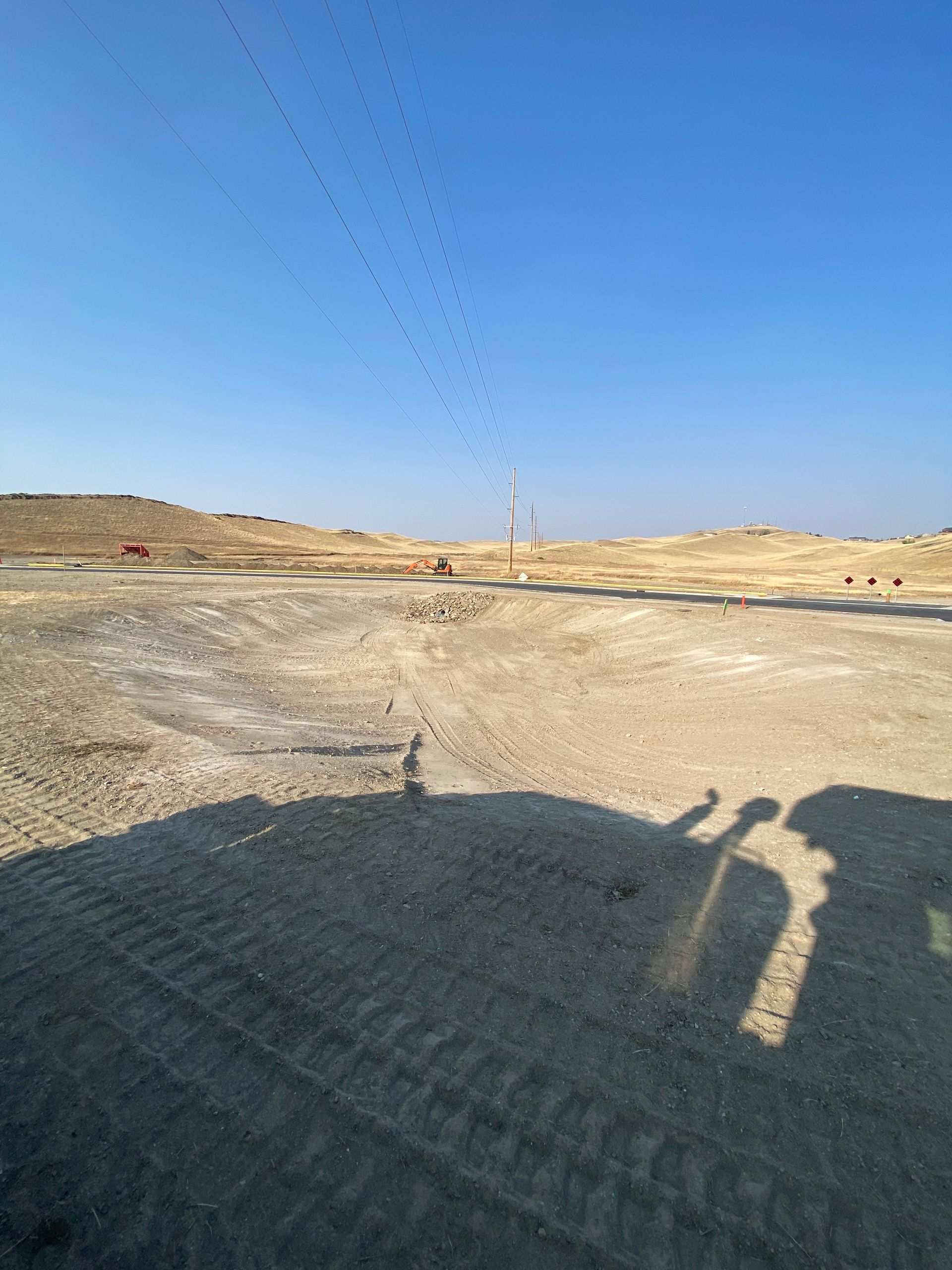 A shadow of a person is cast on the ground in the desert.