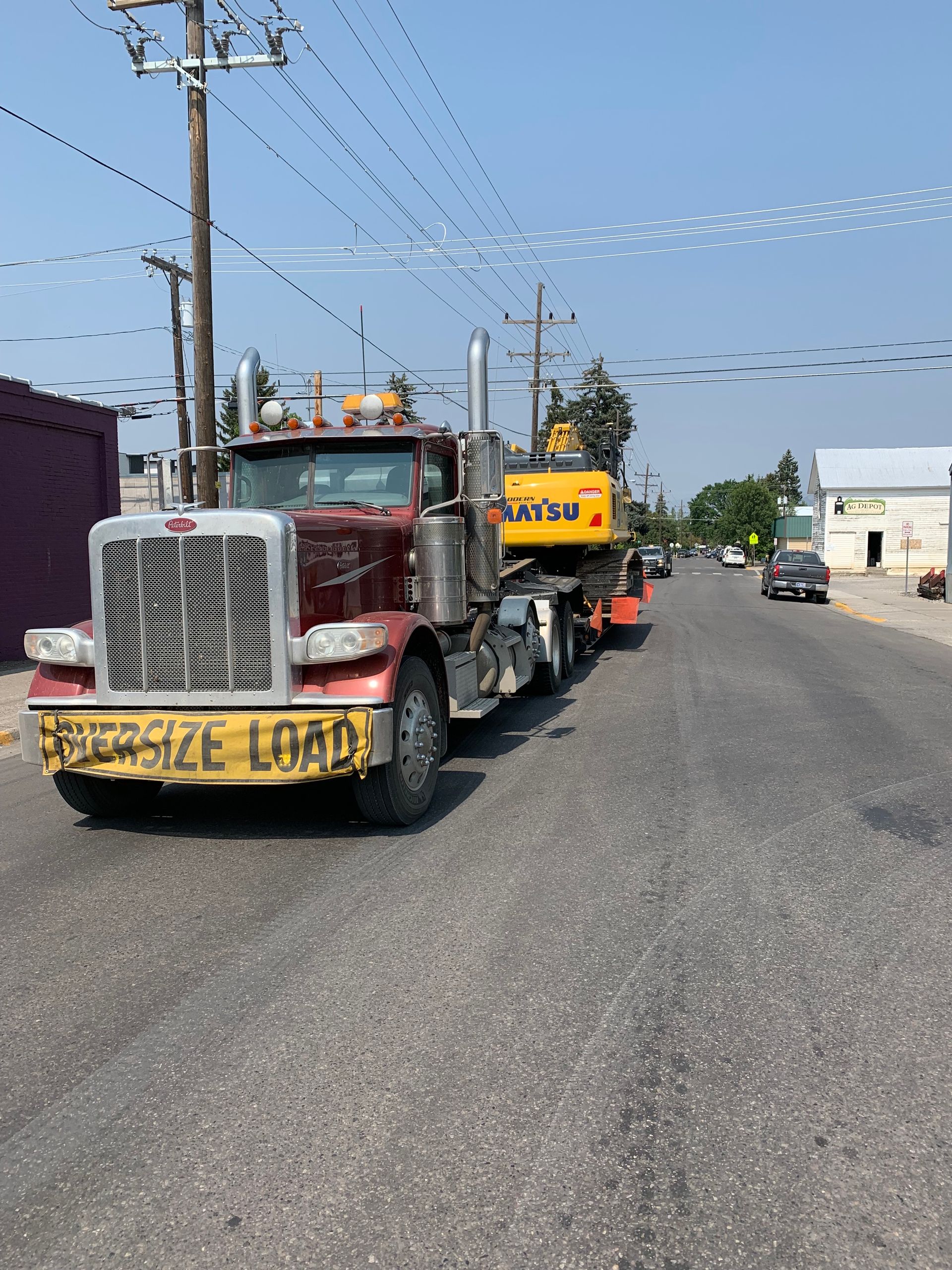 A semi truck is driving down a street with a yellow sign on the front that says special load.