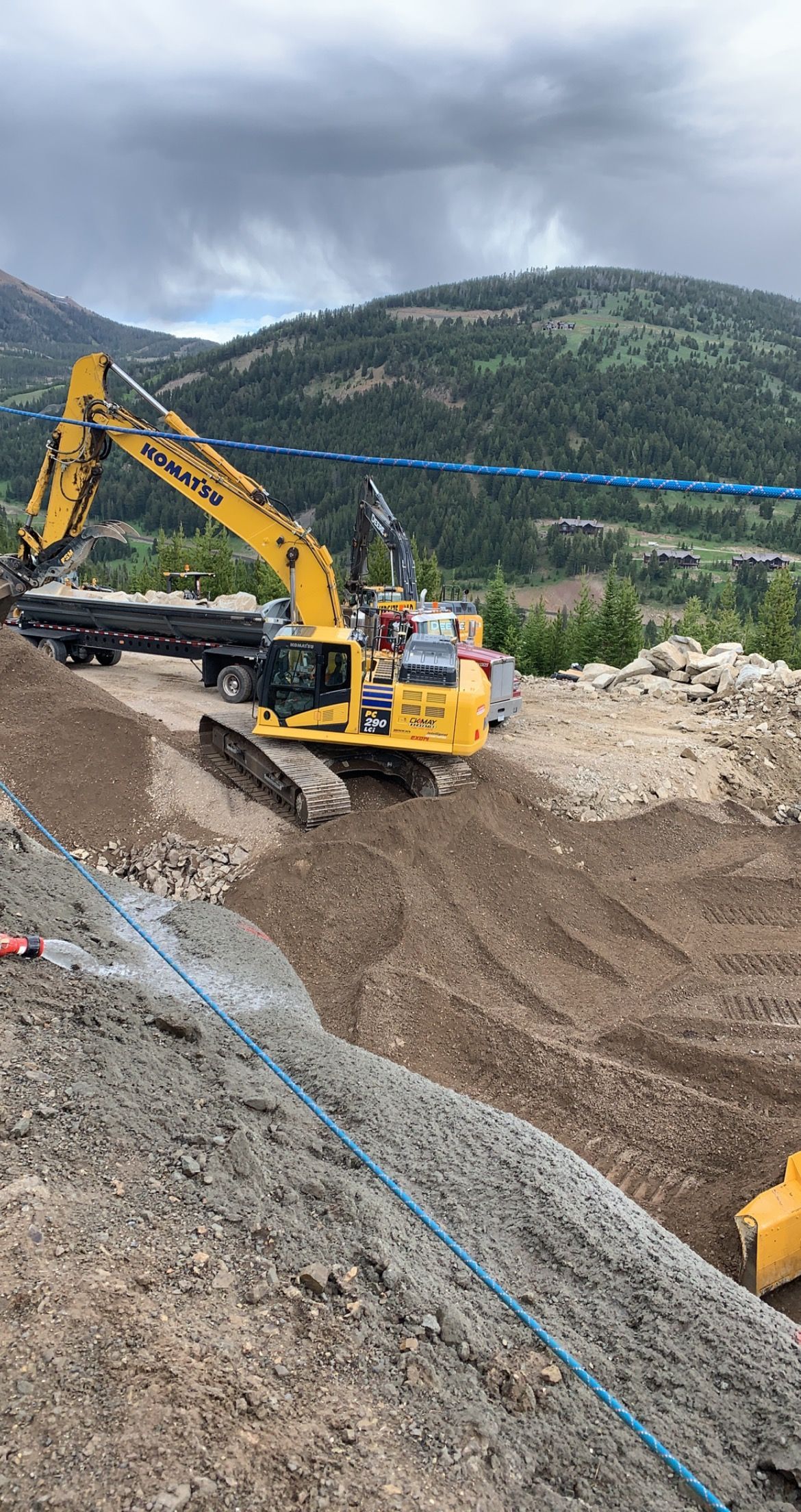 A large yellow excavator is digging a hole in the dirt.