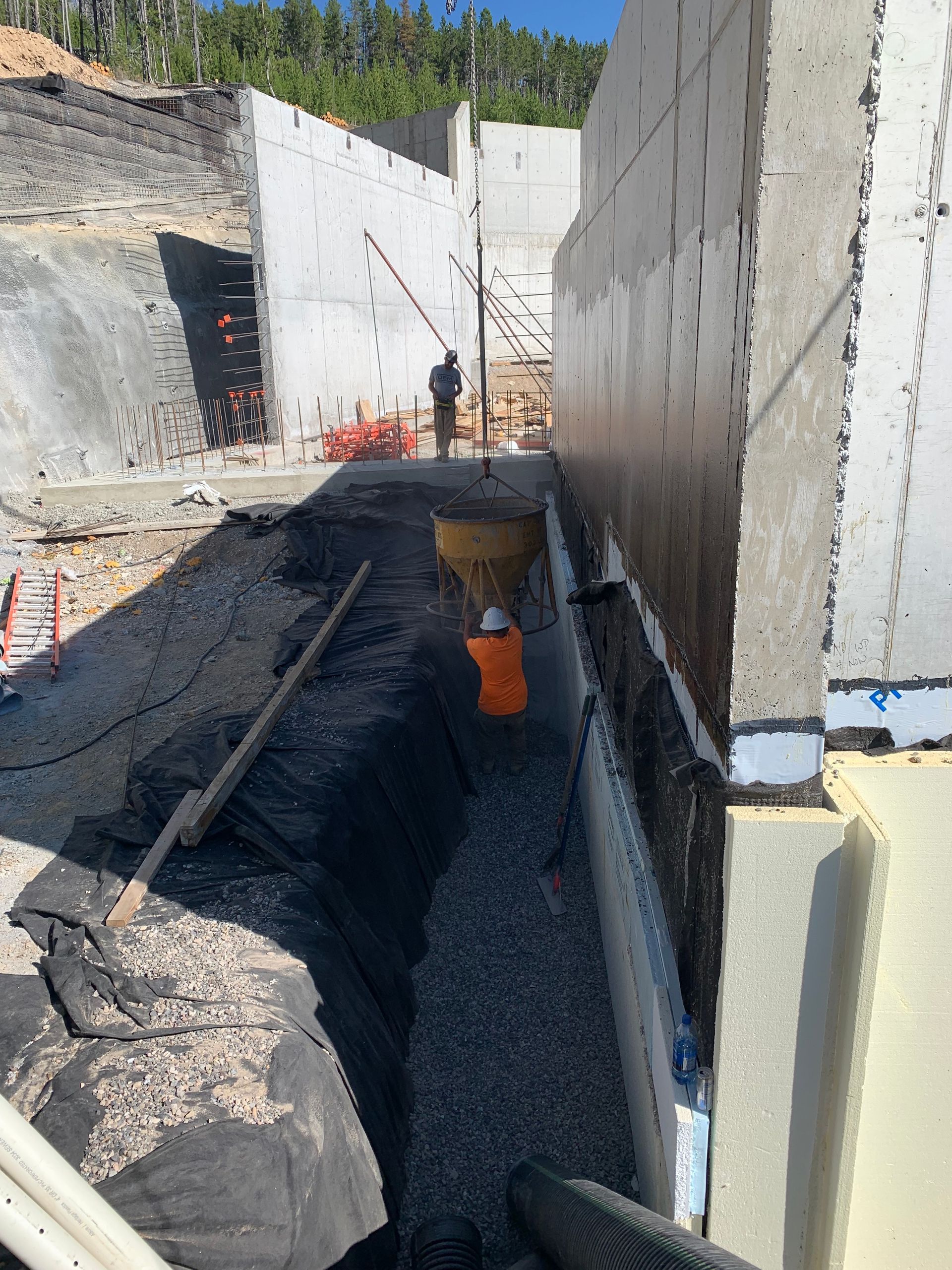 A construction site with a bucket of gravel and a shovel.