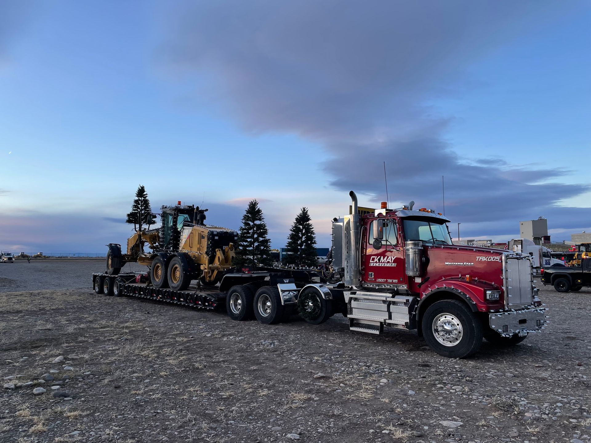 A red semi truck is carrying a bulldozer on a trailer.