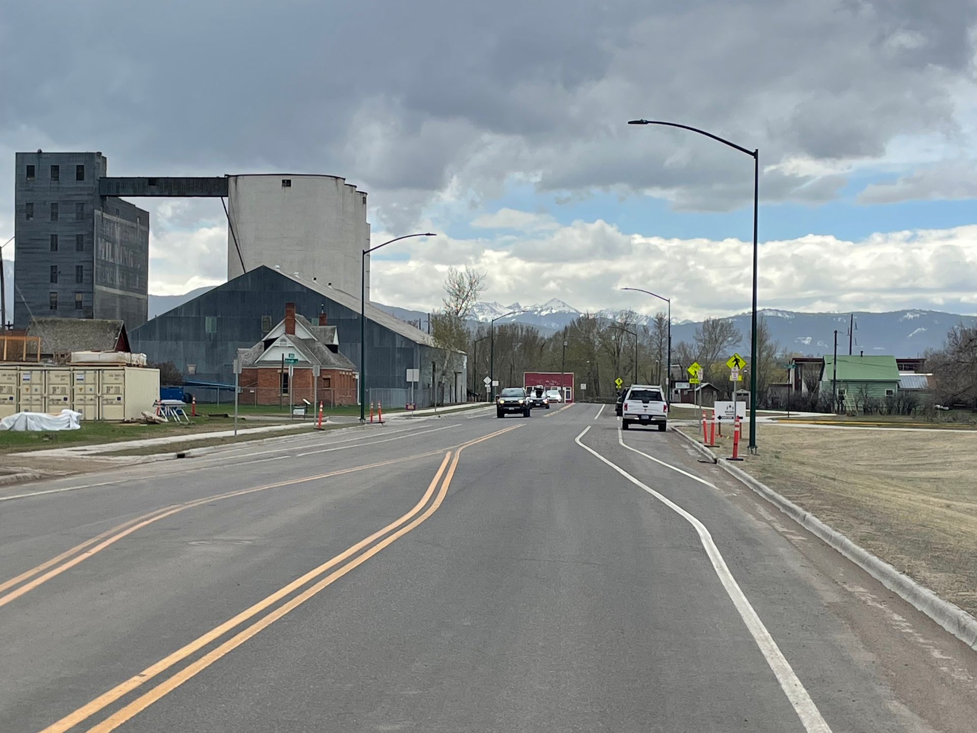 A road with cars driving down it and a building in the background.