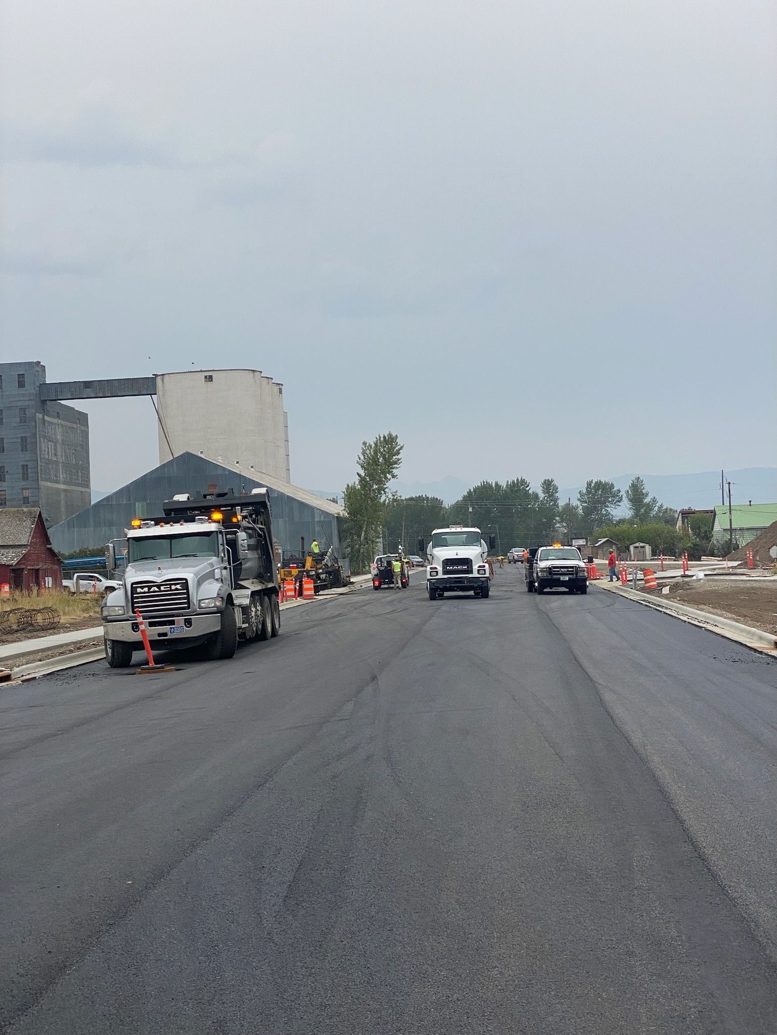 A group of trucks are driving down a road.