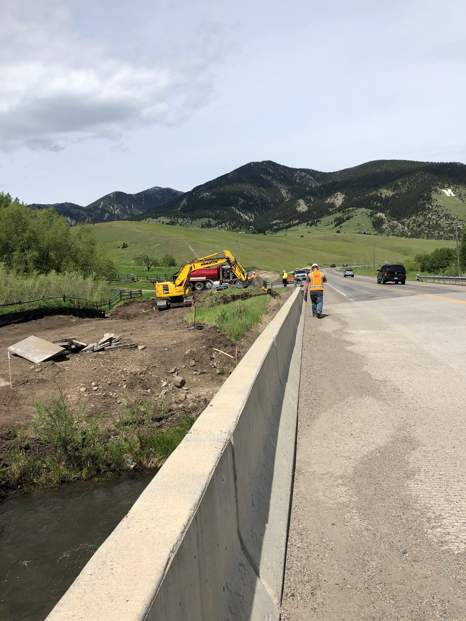 A group of construction workers are working on a bridge over a river.