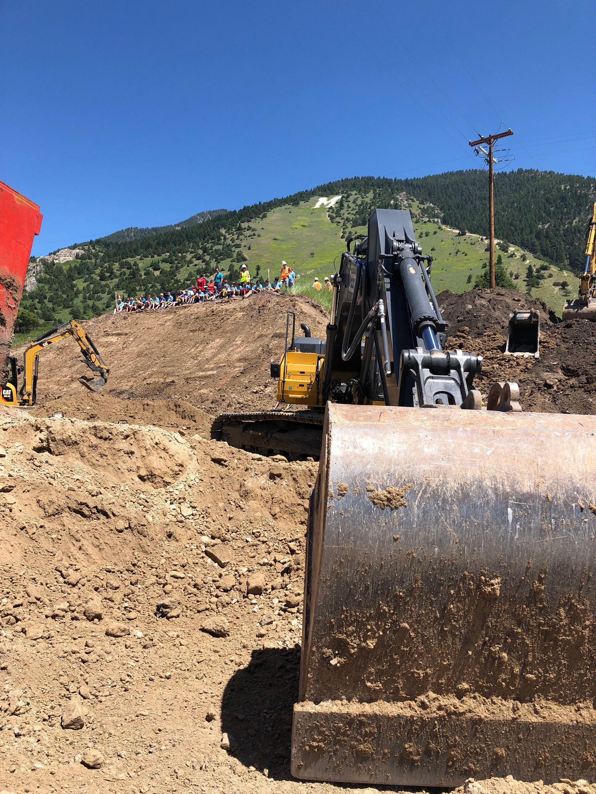 A bulldozer is sitting on top of a dirt hill.