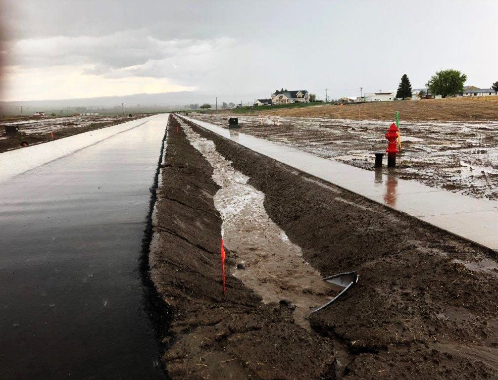 A muddy road with a fire hydrant on the side of it.