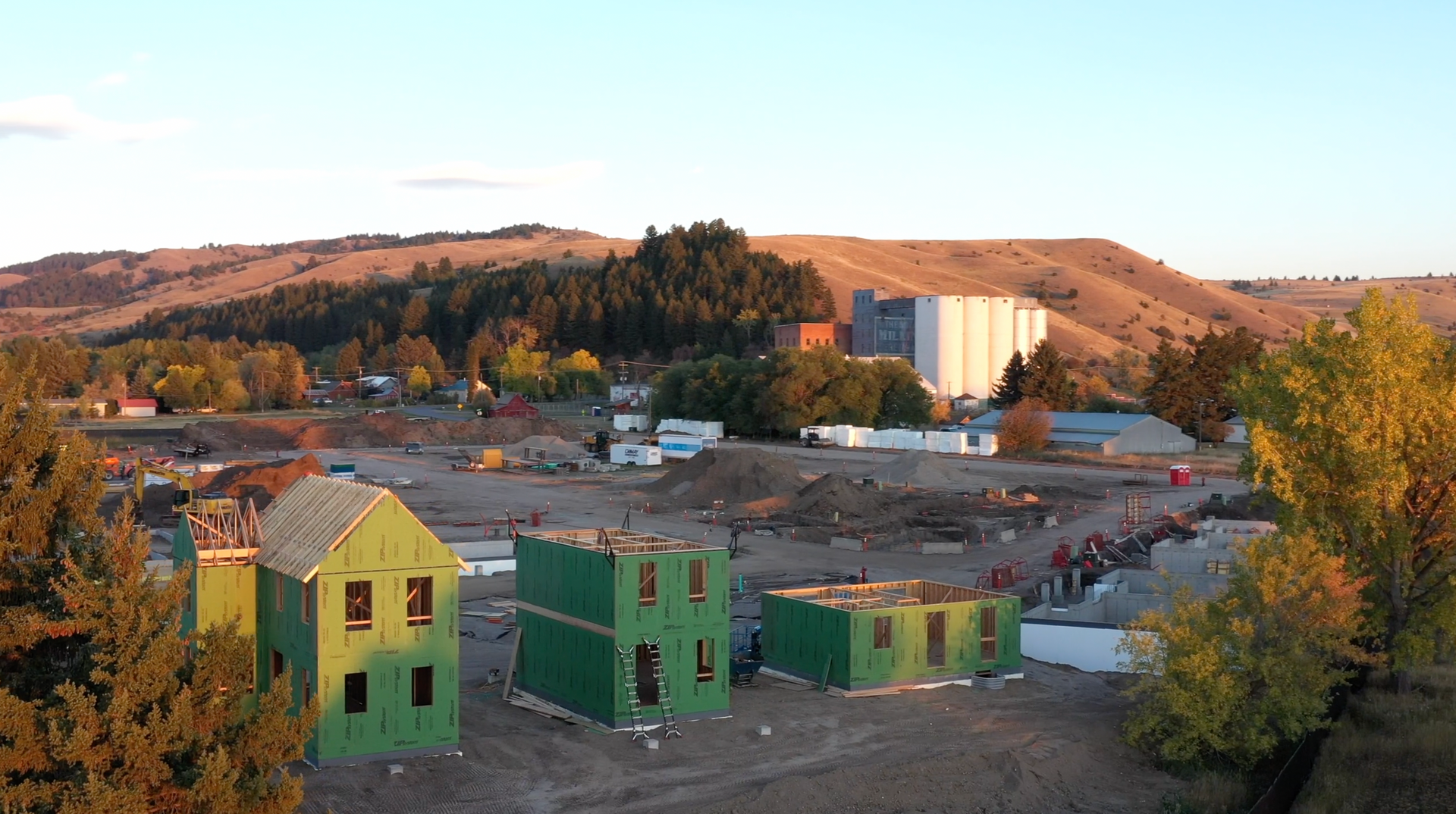 An aerial view of a building under construction with a mountain in the background