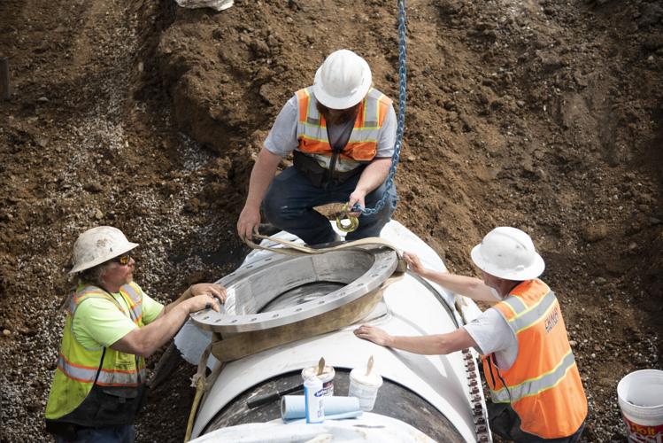 A group of construction workers are working on a pipe