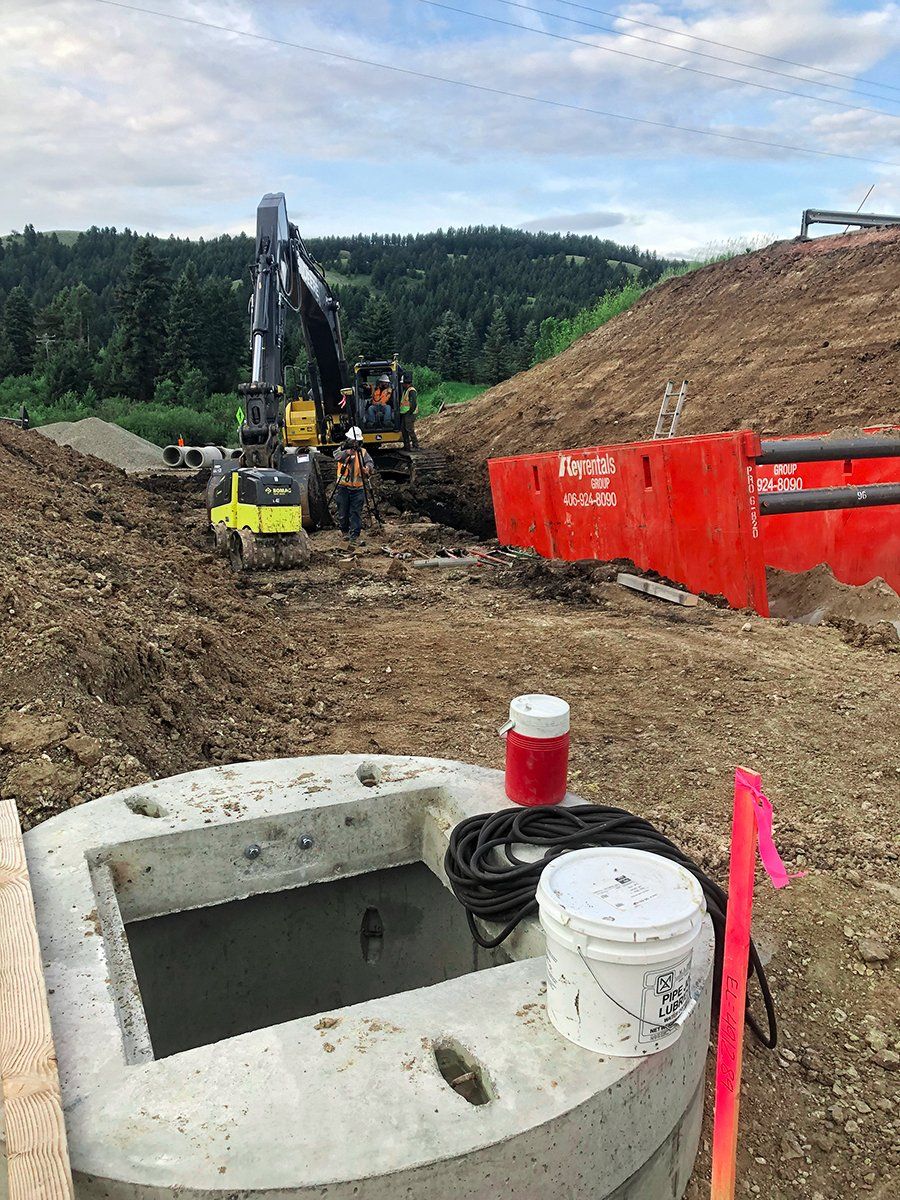 A large excavator is digging a hole in the dirt on a construction site.