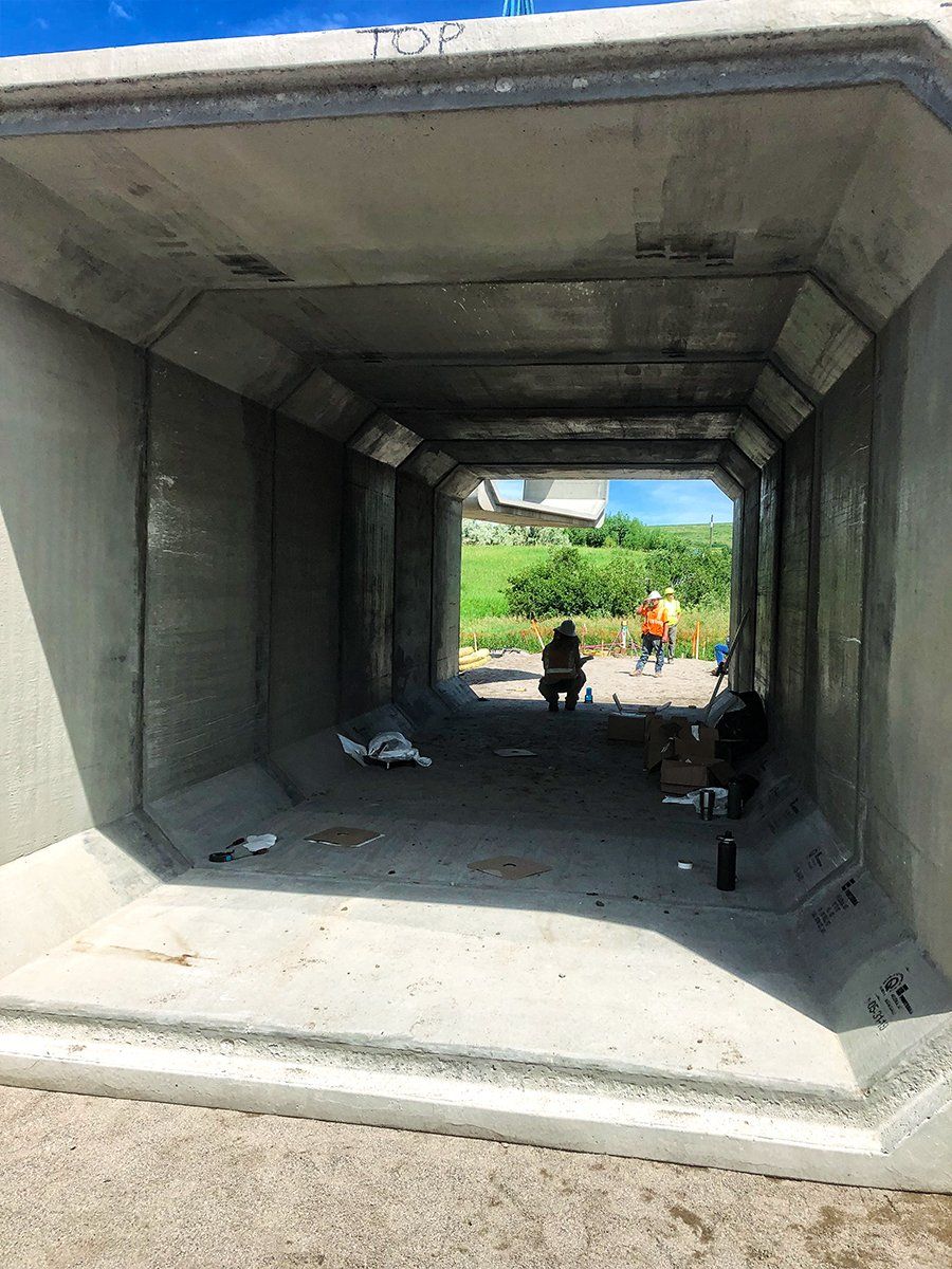 A man is standing in the middle of a tunnel.