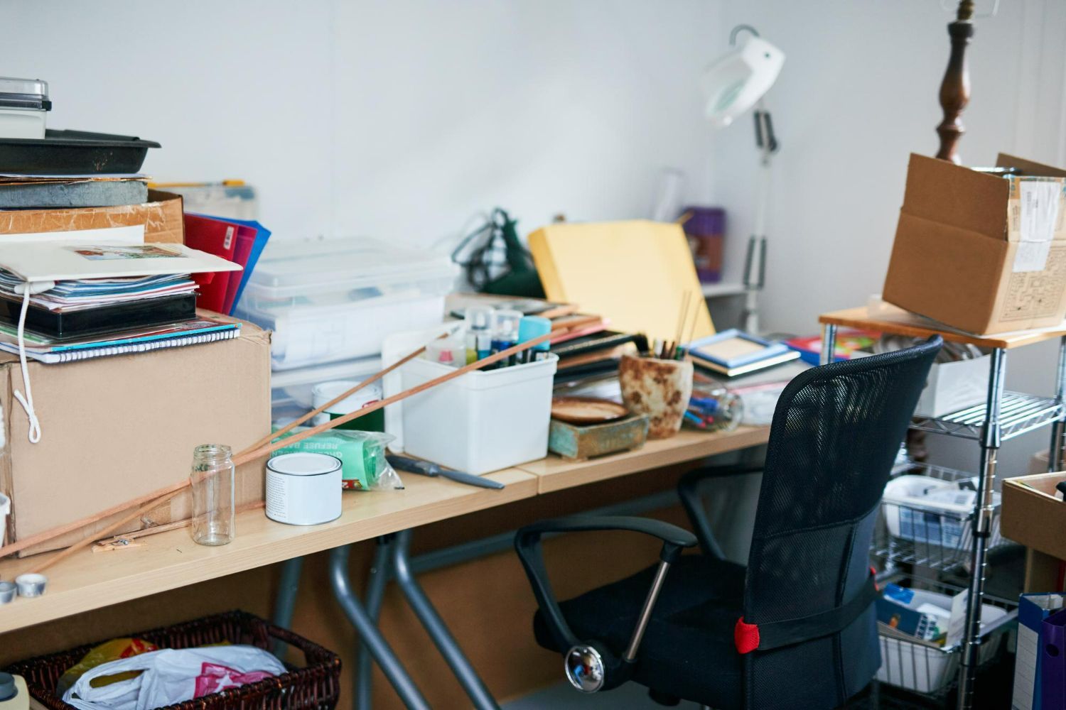 A messy desk with a chair and boxes on it.